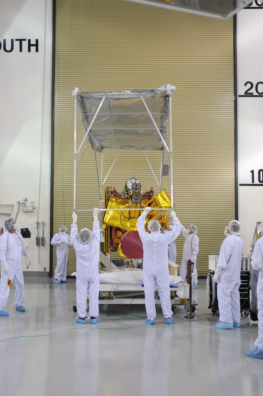 VANDENBERG AIR FORCE BASE, Calif. – Inside the Astrotech payload processing facility on Vandenberg Air Force Base in California, engineers and technicians remove a protective covering from NASA's Soil Moisture Active Passive, or SMAP, spacecraft.    SMAP will launch on a Delta II 7320 configuration vehicle featuring a United Launch Alliance first stage booster powered by an Aerojet Rocketdyne RS-27A main engine and three Alliant Techsystems, or ATK, strap-on solid rocket motors. Once on station in Earth orbit, SMAP will provide global measurements of soil moisture and its freeze/thaw state. These measurements will be used to enhance understanding of processes that link the water, energy and carbon cycles, and to extend the capabilities of weather and climate prediction models. SMAP data also will be used to quantify net carbon flux in boreal landscapes and to develop improved flood prediction and drought monitoring capabilities. Launch from Space Launch Complex 2 is targeted for Jan. 29, 2015. To learn more about SMAP, visit http://smap.jpl.nasa.gov Photo credit: NASA/ Robert Rasmison