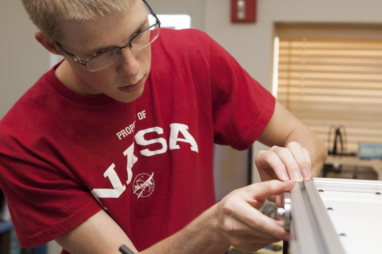 CAPE CANAVERAL, Fla. – Inside the Prototype Laboratory at NASA's Kennedy Space Center in Florida, Evan Williams, an Education intern from the University of Central Florida, prepares the experiment container for NASA's Exposing Microorganisms in the Stratosphere, or E-MIST, experiment. The container was designed and built at Kennedy. The 80-pound structure features four doors that rotate to expose up to 10 microbial samples each for a predetermined period of time in the Earth's stratosphere.    The E-MIST experiment will launch on the exterior of a giant scientific balloon gondola at about 8 a.m. MST on Aug. 24 from Ft. Sumner, New Mexico. It will soar 125,000 feet above the Earth during a 5-hour journey over the desert to understand how spore-forming bacteria, commonly found in spacecraft assembly facilities can survive. Photo credit: NASA/Kim Shiflett
