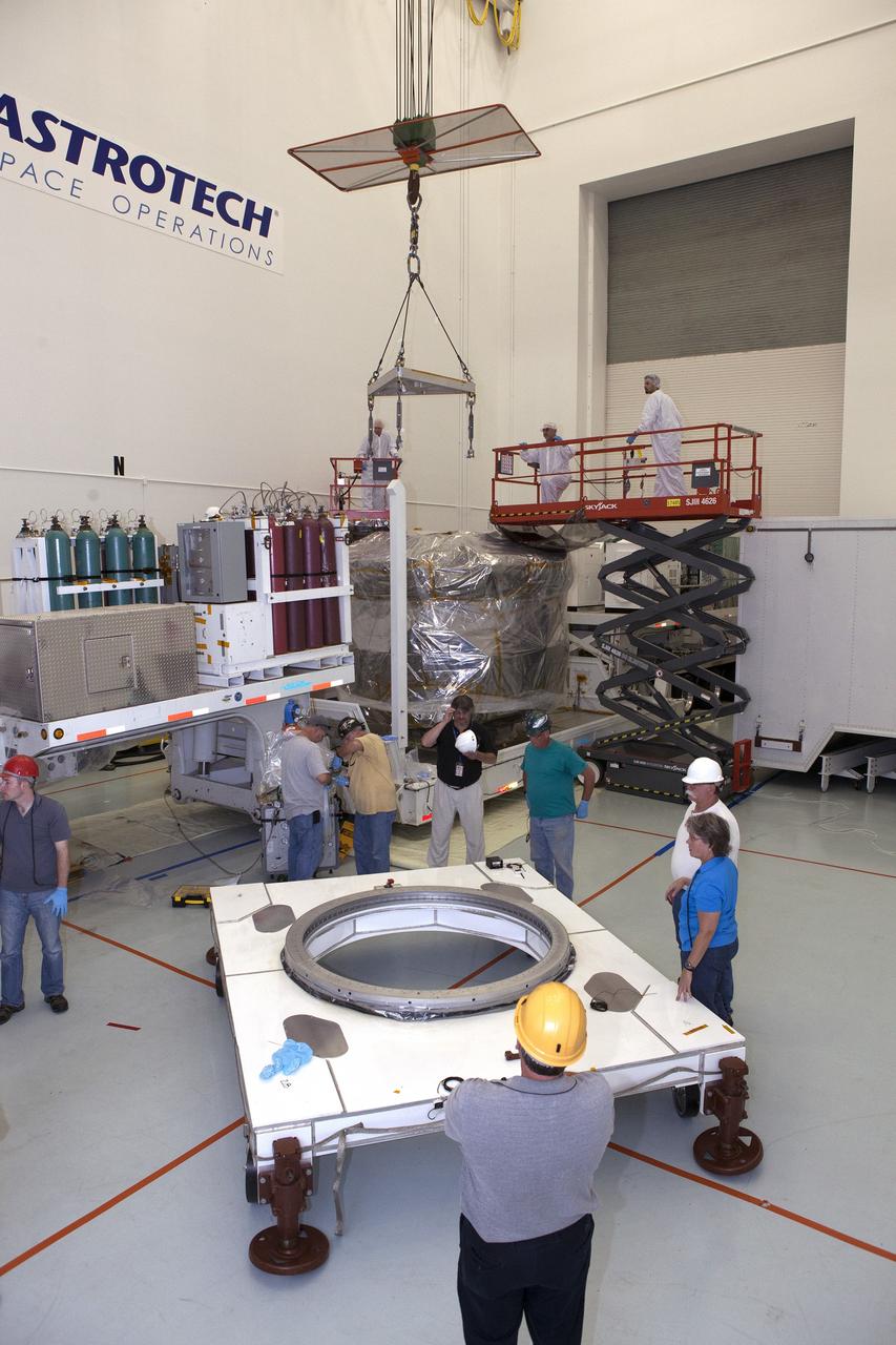 CAPE CANAVERAL, Fla. – A crane is lowered toward the lower stack, mini-stack number 1, two of the observatories for NASA's Magnetospheric Multiscale Observatory, or MMS, during uncrating operations in the Building 2 south encapsulation bay at the Astrotech payload processing facility in Titusville, Florida, near Kennedy Space Center.    The MMS upper stack, mini-stack number 2, is scheduled to arrive in about two weeks.  MMS is a Solar Terrestrial Probes mission comprising four identically instrumented spacecraft that will use Earth’s magnetosphere as a laboratory to study the microphysics of three fundamental plasma processes: magnetic reconnection, energetic particle acceleration and turbulence.  Launch aboard a United Launch Alliance Atlas V rocket from Space Launch Complex 41 on Cape Canaveral Air Force Station is targeted for March 12, 2015. To learn more about MMS, visit http://mms.gsfc.nasa.gov.  Photo credit: NASA/Dan Casper