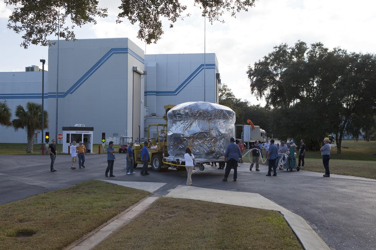 CAPE CANAVERAL, Fla. – Workers surround two of the observatories, the lower stack, mini-stack number 1, for NASA's Magnetospheric Multiscale Observatory, or MMS, on their trip from the Building 2 south encapsulation bay to the Building 1 high bay at the Astrotech payload processing facility in Titusville, Florida, near Kennedy Space Center.    The MMS upper stack, mini-stack number 2, is scheduled to arrive in about two weeks.  MMS is a Solar Terrestrial Probes mission comprising four identically instrumented spacecraft that will use Earth’s magnetosphere as a laboratory to study the microphysics of three fundamental plasma processes: magnetic reconnection, energetic particle acceleration and turbulence.  Launch aboard a United Launch Alliance Atlas V rocket from Space Launch Complex 41 on Cape Canaveral Air Force Station is targeted for March 12, 2015. To learn more about MMS, visit http://mms.gsfc.nasa.gov.  Photo credit: NASA/Dan Casper