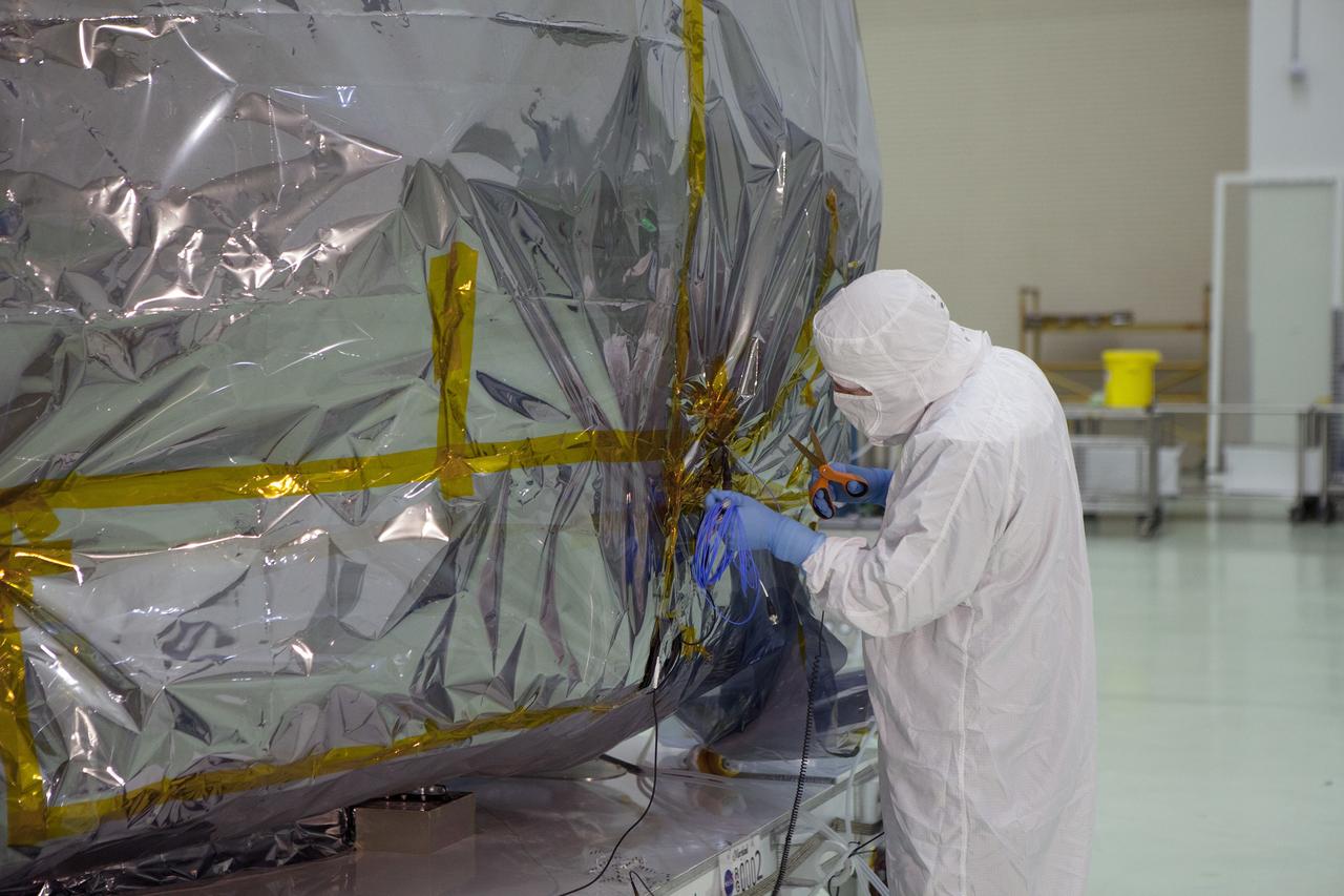 CAPE CANAVERAL, Fla. – A technician prepares to remove the protective covering from the lower stack, mini-stack number 1, two of the observatories for NASA's Magnetospheric Multiscale Observatory, or MMS, in Building 1 D high bay at the Astrotech payload processing facility in Titusville, Florida, near Kennedy Space Center.    The MMS upper stack, mini-stack number 2, is scheduled to arrive in about two weeks.  MMS is a Solar Terrestrial Probes mission comprising four identically instrumented spacecraft that will use Earth’s magnetosphere as a laboratory to study the microphysics of three fundamental plasma processes: magnetic reconnection, energetic particle acceleration and turbulence.  Launch aboard a United Launch Alliance Atlas V rocket from Space Launch Complex 41 on Cape Canaveral Air Force Station is targeted for March 12, 2015. To learn more about MMS, visit http://mms.gsfc.nasa.gov.  Photo credit: NASA/Dan Casper