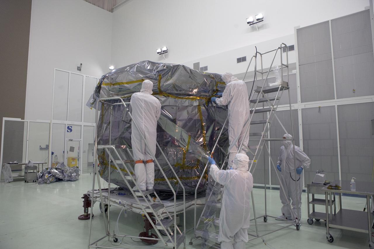 CAPE CANAVERAL, Fla. – Technicians prepare to remove the protective covering from the lower stack, mini-stack number 1, two of the observatories for NASA's Magnetospheric Multiscale Observatory, or MMS, in Building 1 D high bay at the Astrotech payload processing facility in Titusville, Florida, near Kennedy Space Center.    The MMS upper stack, mini-stack number 2, is scheduled to arrive in about two weeks.  MMS is a Solar Terrestrial Probes mission comprising four identically instrumented spacecraft that will use Earth’s magnetosphere as a laboratory to study the microphysics of three fundamental plasma processes: magnetic reconnection, energetic particle acceleration and turbulence.  Launch aboard a United Launch Alliance Atlas V rocket from Space Launch Complex 41 on Cape Canaveral Air Force Station is targeted for March 12, 2015. To learn more about MMS, visit http://mms.gsfc.nasa.gov.  Photo credit: NASA/Dan Casper