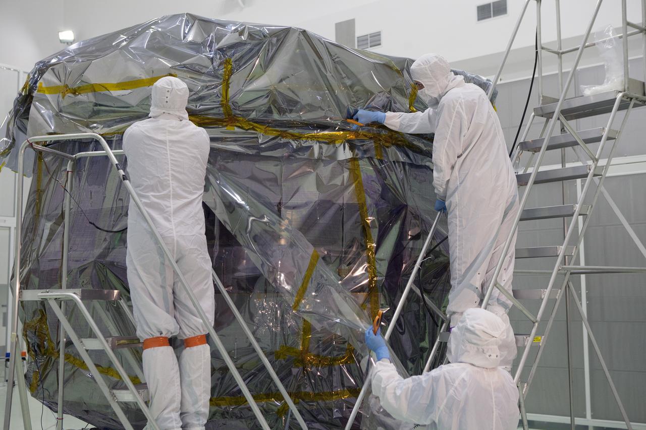 CAPE CANAVERAL, Fla. – Technicians begin to remove the protective covering from the lower stack, mini-stack number 1, two of the observatories for NASA's Magnetospheric Multiscale Observatory, or MMS, in Building 1 D high bay at the Astrotech payload processing facility in Titusville, Florida, near Kennedy Space Center.    The MMS upper stack, mini-stack number 2, is scheduled to arrive in about two weeks.  MMS is a Solar Terrestrial Probes mission comprising four identically instrumented spacecraft that will use Earth’s magnetosphere as a laboratory to study the microphysics of three fundamental plasma processes: magnetic reconnection, energetic particle acceleration and turbulence.  Launch aboard a United Launch Alliance Atlas V rocket from Space Launch Complex 41 on Cape Canaveral Air Force Station is targeted for March 12, 2015. To learn more about MMS, visit http://mms.gsfc.nasa.gov.  Photo credit: NASA/Dan Casper