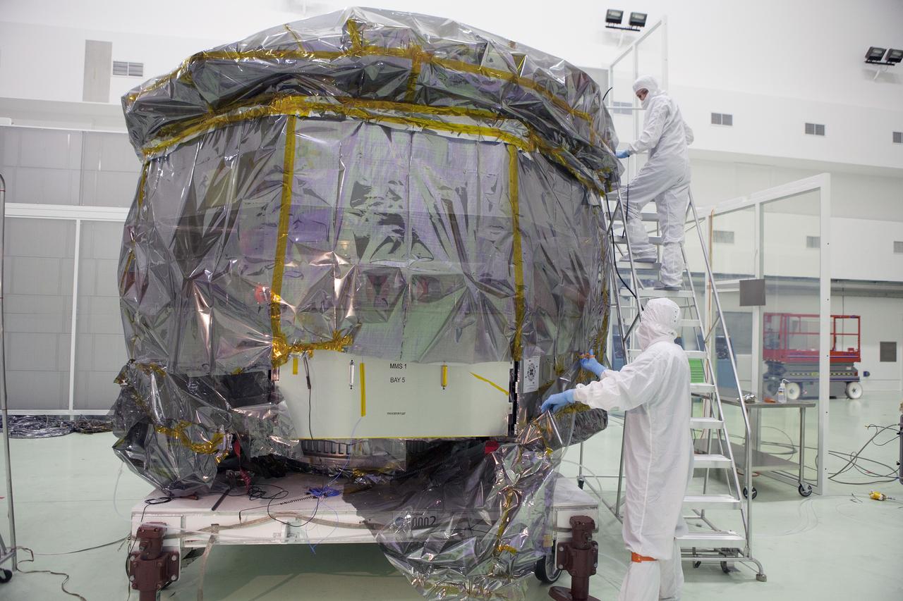 CAPE CANAVERAL, Fla. – Technicians begin to remove the protective covering from the lower stack, mini-stack number 1, two of the observatories for NASA's Magnetospheric Multiscale Observatory, or MMS, in Building 1 D high bay at the Astrotech payload processing facility in Titusville, Florida, near Kennedy Space Center.    The MMS upper stack, mini-stack number 2, is scheduled to arrive in about two weeks.  MMS is a Solar Terrestrial Probes mission comprising four identically instrumented spacecraft that will use Earth’s magnetosphere as a laboratory to study the microphysics of three fundamental plasma processes: magnetic reconnection, energetic particle acceleration and turbulence.  Launch aboard a United Launch Alliance Atlas V rocket from Space Launch Complex 41 on Cape Canaveral Air Force Station is targeted for March 12, 2015. To learn more about MMS, visit http://mms.gsfc.nasa.gov.  Photo credit: NASA/Dan Casper