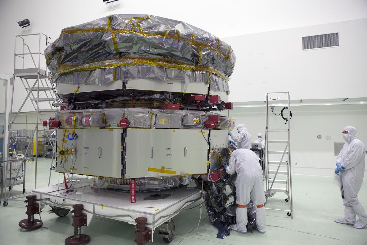 CAPE CANAVERAL, Fla. – Technicians remove the protective covering from the lower stack, mini-stack number 1, two of the observatories for NASA's Magnetospheric Multiscale Observatory, or MMS, in Building 1 D high bay at the Astrotech payload processing facility in Titusville, Florida, near Kennedy Space Center.    The MMS upper stack, mini-stack number 2, is scheduled to arrive in about two weeks.  MMS is a Solar Terrestrial Probes mission comprising four identically instrumented spacecraft that will use Earth’s magnetosphere as a laboratory to study the microphysics of three fundamental plasma processes: magnetic reconnection, energetic particle acceleration and turbulence.  Launch aboard a United Launch Alliance Atlas V rocket from Space Launch Complex 41 on Cape Canaveral Air Force Station is targeted for March 12, 2015. To learn more about MMS, visit http://mms.gsfc.nasa.gov.  Photo credit: NASA/Dan Casper