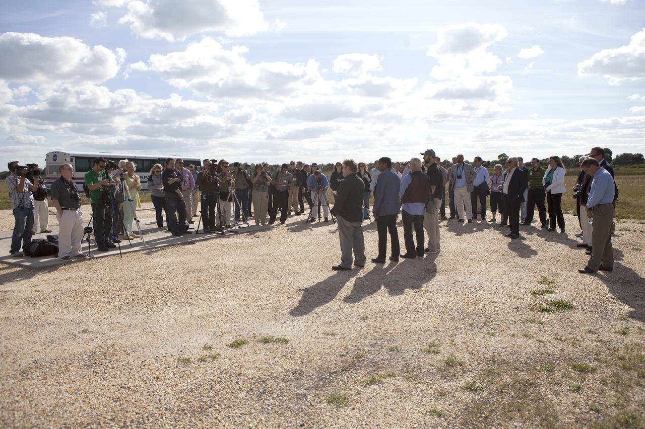 CAPE CANAVERAL, Fla. - Bob Richards, standing at left in front of the cameras, co-founder and chief executive officer of Moon Express Inc., of Moffett Field, California, speaks to the media during an event to announce the company's selection to utilize Kennedy Space Center facilities as part of NASA's Lunar Cargo Transportation and Landing by Soft Touchdown, or Lunar CATALYST, initiative. Third from left in the group is former NASA Apollo astronaut Buzz Aldrin. The event took place at Kennedy's automated landing and hazard avoidance technology, or ALHAT, hazard field at the north end of the Shuttle Landing Facility.    Moon Express is developing a lander with capabilities that will enable delivery of payloads to the surface of the moon, as well as new science and exploration missions of interest to  NASA and scientific and academic communities. Moon Express will base its activities at Kennedy and utilize the Morpheus ALHAT field and a hangar nearby for CATALYST testing. The Advanced Exploration Systems Division of NASA's Human Exploration and Operations Mission Directorate manages Lunar CATALYST. Photo credit: NASA/Ben Smegelsky