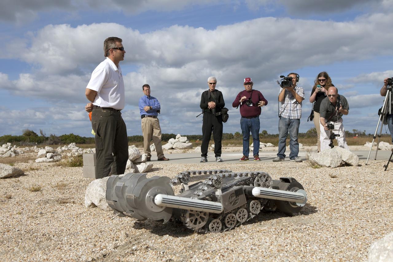 CAPE CANAVERAL, Fla. - Rob Mueller, NASA senior technologist in the Surface Systems Office in Kennedy Space Center's Engineering and Technology Directorate, demonstrates the Regolith Advanced Surface System Operations Robot, or RASSOR, during a media event at Kennedy's automated landing and hazard avoidance technology, or ALHAT, hazard field at the north end of the Shuttle Landing Facility. The event was held to announce Moon Express Inc., of Moffett Field, California is selected to utilize Kennedy facilities for NASA's Lunar Cargo Transportation and Landing by Soft Touchdown, or Lunar CATALYST, initiative.     Moon Express is developing a lander with capabilities that will enable delivery of payloads to the surface of the moon, as well as new science and exploration missions of interest to  NASA and scientific and academic communities. Moon Express will base its activities at Kennedy and utilize the Morpheus ALHAT field and a hangar nearby for CATALYST testing. The Advanced Exploration Systems Division of NASA's Human Exploration and Operations Mission Directorate manages Lunar CATALYST. Photo credit: NASA/Ben Smegelsky