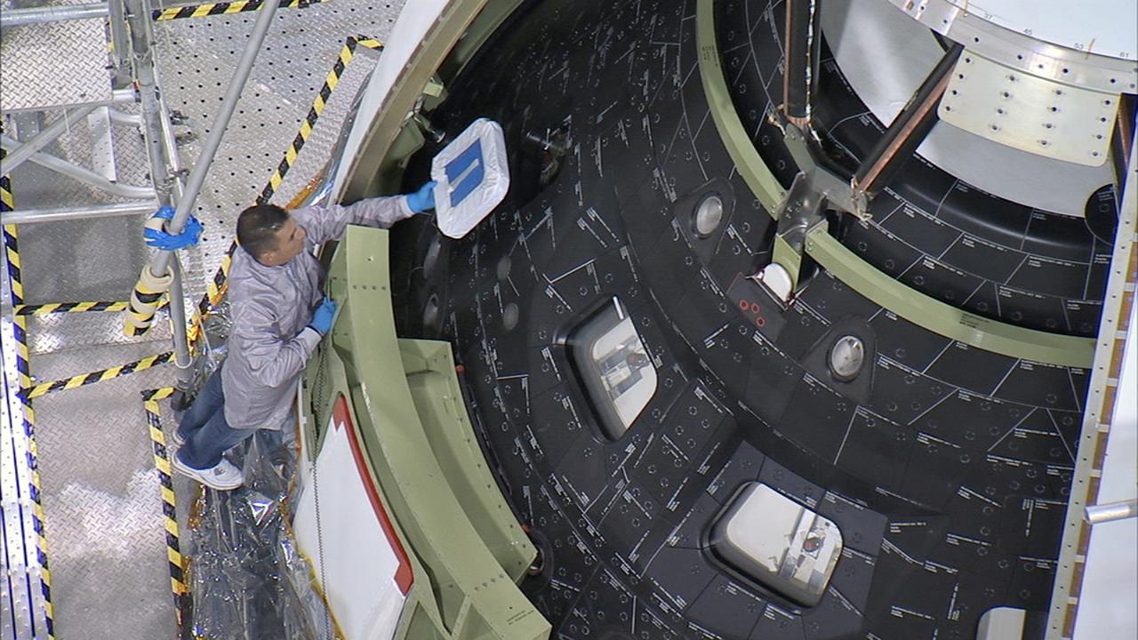 CAPE CANAVERAL, Fla. – Inside the Launch Abort System Facility at NASA's Kennedy Space Center in Florida, a technician on a work platform carefully removes the window covers on Orion before the fourth and final Ogive panel is installed around the spacecraft and Launch Abort System. The Ogive panels will smooth the airflow over the conical spacecraft to limit sound and vibration, which will make for a much smoother ride for the astronauts who will ride inside Orion in the future. The work marked the final major assembly steps for the spacecraft before it is transported to Space Launch Complex 37 at Cape Canaveral Air Force Station in November. Orion is the exploration spacecraft designed to carry astronauts to destinations not yet explored by humans, including an asteroid and Mars. It will have emergency abort capability, sustain the crew during space travel and provide safe re-entry from deep space return velocities. The first unpiloted flight test of Orion is scheduled to launch in December 2014 atop a United Launch Alliance Delta IV Heavy rocket, and in 2018 on NASA’s Space Launch System rocket. For more information, visit www.nasa.gov/orion. Photo credit: Ben Smegelsky