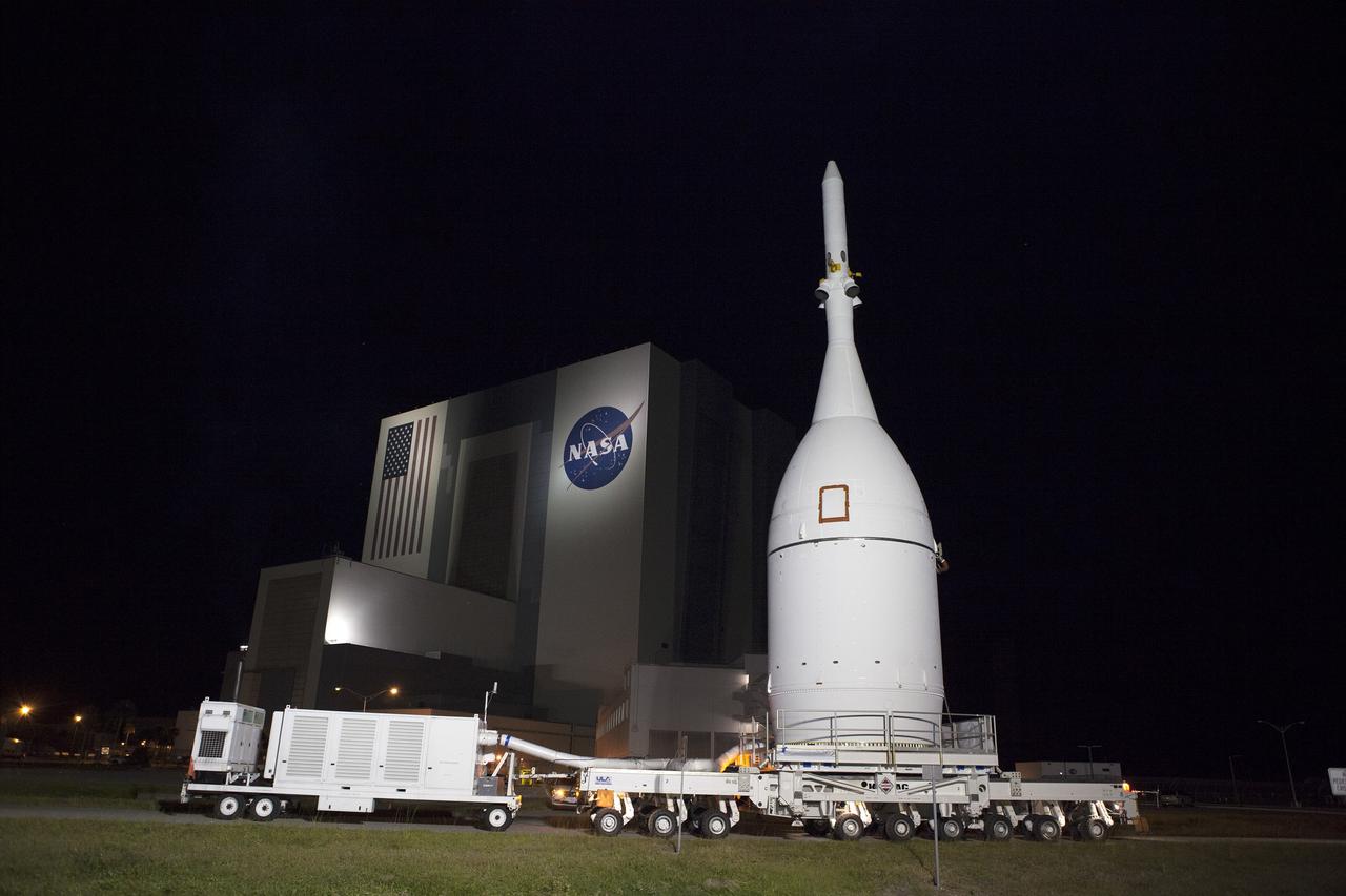 CAPE CANAVERAL, Fla. – At NASA's Kennedy Space Center in Florida, the agency's Orion spacecraft passes the spaceport's iconic Vehicle Assembly Building as it is transported to Launch Complex 37 at Cape Canaveral Air Force Station. After arrival at the launch pad, United Launch Alliance engineers and technicians will lift Orion and mount it atop its Delta IV Heavy rocket.      Orion is the exploration spacecraft designed to carry astronauts to destinations not yet explored by humans, including an asteroid and Mars. It will have emergency abort capability, sustain the crew during space travel and provide safe re-entry from deep space return velocities. The first unpiloted flight test of Orion is scheduled to launch Dec. 4, 2014 atop a United Launch Alliance Delta IV Heavy rocket, and in 2018 on NASA’s Space Launch System rocket. For more information, visit www.nasa.gov/orion Photo credit: NASA/Frankie Martin