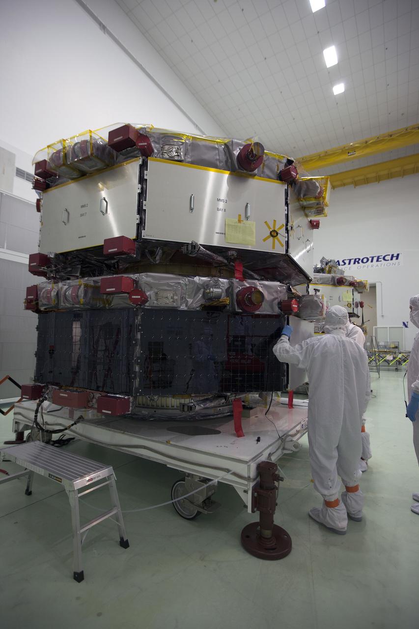 CAPE CANAVERAL, Fla. – Workers inspect the solar arrays on the Magnetospheric Multiscale, or MMS, observatories in the Building 1 D high bay of the Astrotech payload processing facility in Titusville, Florida, near Kennedy Space Center. The two MMS spacecraft comprising the upper deck arrived Nov. 12; the two comprising the lower stack arrived Oct. 29. MMS, led by a team from NASA's Goddard Space Flight Center, is a Solar Terrestrial Probes mission consisting of four identically instrumented spacecraft that will use Earth’s magnetosphere as a laboratory to study the microphysics of three fundamental plasma processes: magnetic reconnection, energetic particle acceleration and turbulence. Launch aboard a United Launch Alliance Atlas V rocket from Space Launch Complex 41 on Cape Canaveral Air Force Station is targeted for March 12, 2015. To learn more about MMS, visit http://mms.gsfc.nasa.gov.  Photo credit: NASA/Kim Shiflett