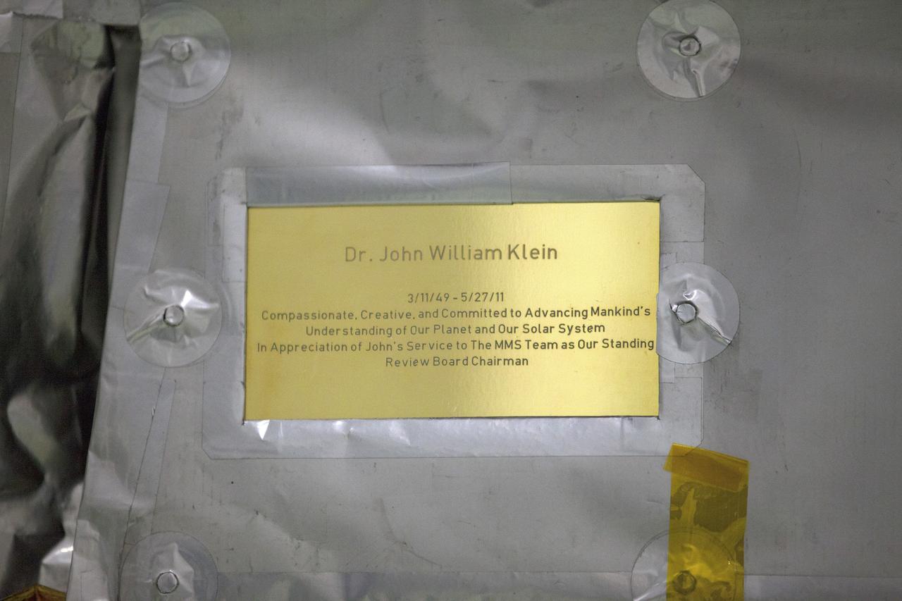 CAPE CANAVERAL, Fla. – A plaque affixed to the side of a Magnetospheric Multiscale, or MMS, observatory dedicates the mission to Dr. John William Klein, now deceased, who served the MMS team as the standing review board chairman. MMS, led by a team from NASA's Goddard Space Flight Center, is a Solar Terrestrial Probes mission consisting of four identically instrumented spacecraft that will use Earth’s magnetosphere as a laboratory to study the microphysics of three fundamental plasma processes: magnetic reconnection, energetic particle acceleration and turbulence. Launch aboard a United Launch Alliance Atlas V rocket from Space Launch Complex 41 on Cape Canaveral Air Force Station is targeted for March 12, 2015. To learn more about MMS, visit http://mms.gsfc.nasa.gov.  Photo credit: NASA/Kim Shiflett