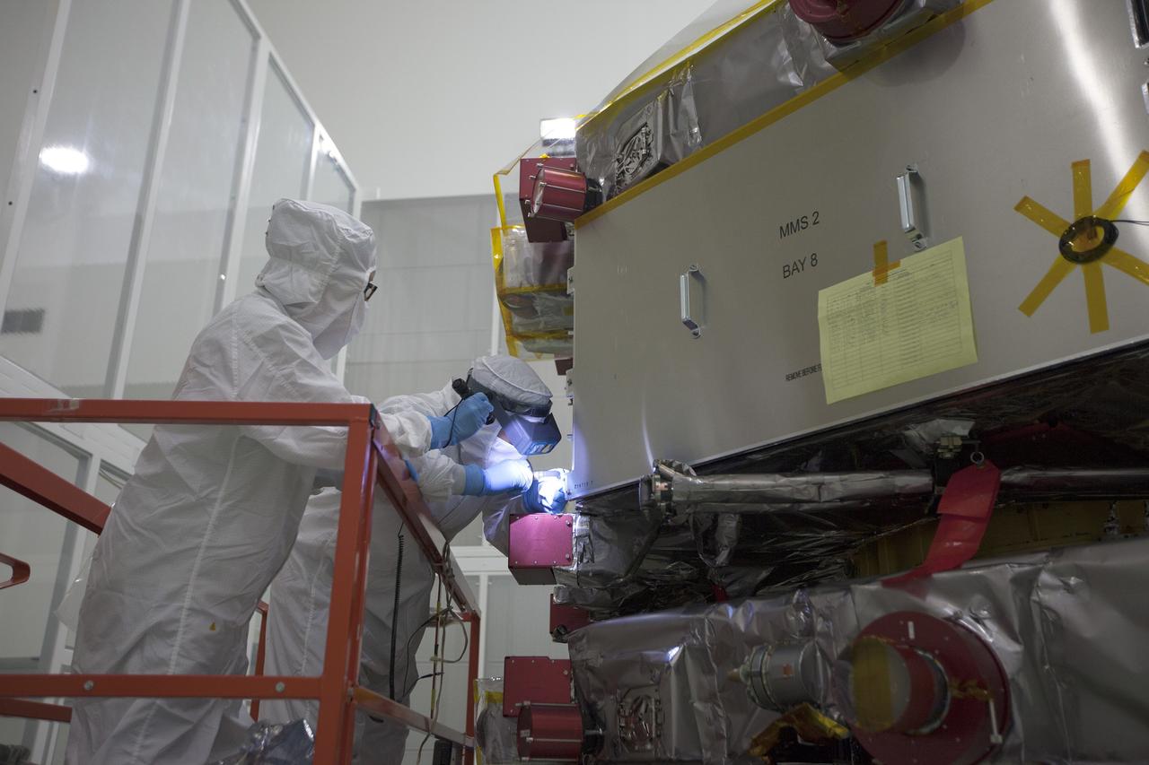 CAPE CANAVERAL, Fla. – Workers inspect the solar arrays on the Magnetospheric Multiscale, or MMS, observatories in the Building 1 D high bay of the Astrotech payload processing facility in Titusville, Florida, near Kennedy Space Center. The two MMS spacecraft comprising the upper deck arrived Nov. 12; the two comprising the lower stack arrived Oct. 29. MMS, led by a team from NASA's Goddard Space Flight Center, is a Solar Terrestrial Probes mission consisting of four identically instrumented spacecraft that will use Earth’s magnetosphere as a laboratory to study the microphysics of three fundamental plasma processes: magnetic reconnection, energetic particle acceleration and turbulence. Launch aboard a United Launch Alliance Atlas V rocket from Space Launch Complex 41 on Cape Canaveral Air Force Station is targeted for March 12, 2015. To learn more about MMS, visit http://mms.gsfc.nasa.gov.  Photo credit: NASA/Kim Shiflett