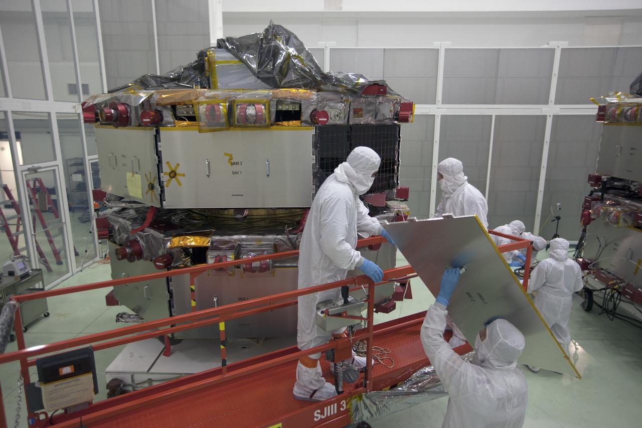 CAPE CANAVERAL, Fla. – Workers inspect the solar arrays on the Magnetospheric Multiscale, or MMS, observatories in the Building 1 D high bay of the Astrotech payload processing facility in Titusville, Florida, near Kennedy Space Center. The two MMS spacecraft comprising the upper deck arrived Nov. 12; the two comprising the lower stack arrived Oct. 29. MMS, led by a team from NASA's Goddard Space Flight Center, is a Solar Terrestrial Probes mission consisting of four identically instrumented spacecraft that will use Earth’s magnetosphere as a laboratory to study the microphysics of three fundamental plasma processes: magnetic reconnection, energetic particle acceleration and turbulence. Launch aboard a United Launch Alliance Atlas V rocket from Space Launch Complex 41 on Cape Canaveral Air Force Station is targeted for March 12, 2015. To learn more about MMS, visit http://mms.gsfc.nasa.gov.  Photo credit: NASA/Kim Shiflett