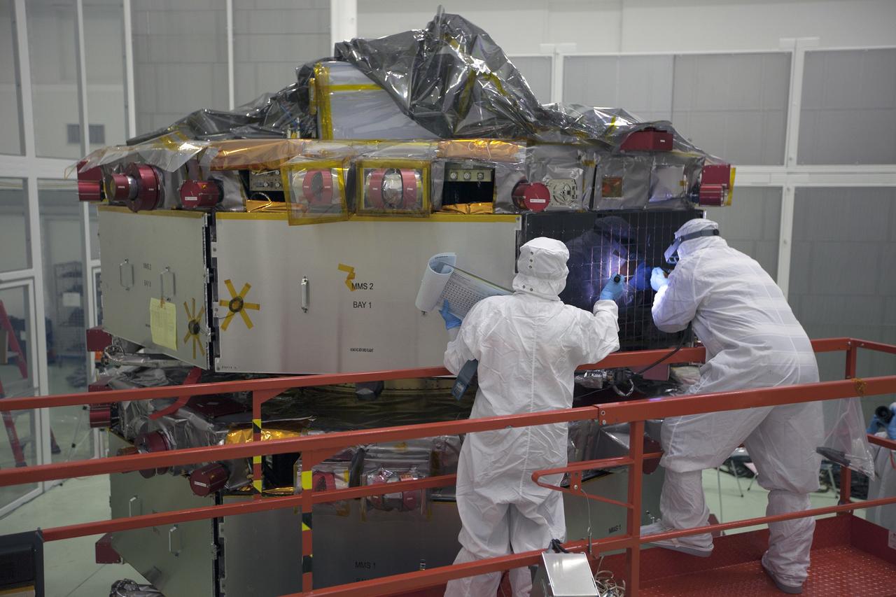 CAPE CANAVERAL, Fla. – Workers inspect the solar arrays on the Magnetospheric Multiscale, or MMS, observatories in the Building 1 D high bay of the Astrotech payload processing facility in Titusville, Florida, near Kennedy Space Center. The two MMS spacecraft comprising the upper deck arrived Nov. 12; the two comprising the lower stack arrived Oct. 29. MMS, led by a team from NASA's Goddard Space Flight Center, is a Solar Terrestrial Probes mission consisting of four identically instrumented spacecraft that will use Earth’s magnetosphere as a laboratory to study the microphysics of three fundamental plasma processes: magnetic reconnection, energetic particle acceleration and turbulence. Launch aboard a United Launch Alliance Atlas V rocket from Space Launch Complex 41 on Cape Canaveral Air Force Station is targeted for March 12, 2015. To learn more about MMS, visit http://mms.gsfc.nasa.gov.  Photo credit: NASA/Kim Shiflett