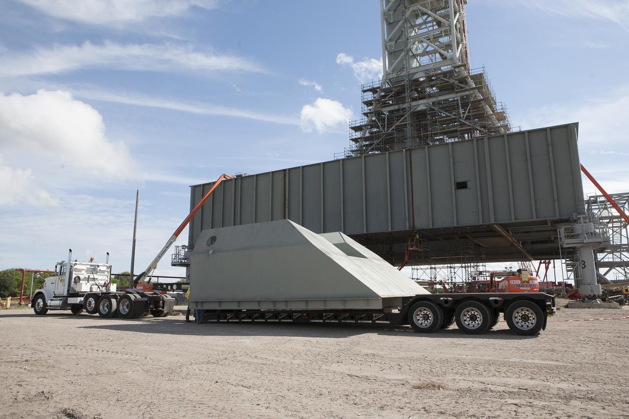 CAPE CANAVERAL, Fla. -- Modifications continue on the Mobile Launcher, or ML, at the Mobile Launcher Park Site at NASA’s Kennedy Space Center in Florida. The haunch, a structure that will support the launch vehicle on the ML, arrives by flatbed truck at the park site. The ML is being modified and strengthened to accommodate the weight, size and thrust at launch of NASA's Space Launch System, or SLS, and Orion spacecraft.    In 2013, the agency awarded a contract to J.P. Donovan Construction Inc. of Rockledge, Fla., to modify the ML, which is one of the key elements of ground support equipment that is being upgraded by the Ground Systems Development and Operations Program at Kennedy. The existing 24-foot exhaust hole is being enlarged and strengthened for the larger, heavier SLS rocket. The ML will carry the SLS rocket and Orion spacecraft to Launch Pad 39B for its first uncrewed mission, Exploration Mission-1, in 2018. Photo credit: NASA/Kim Shiflett