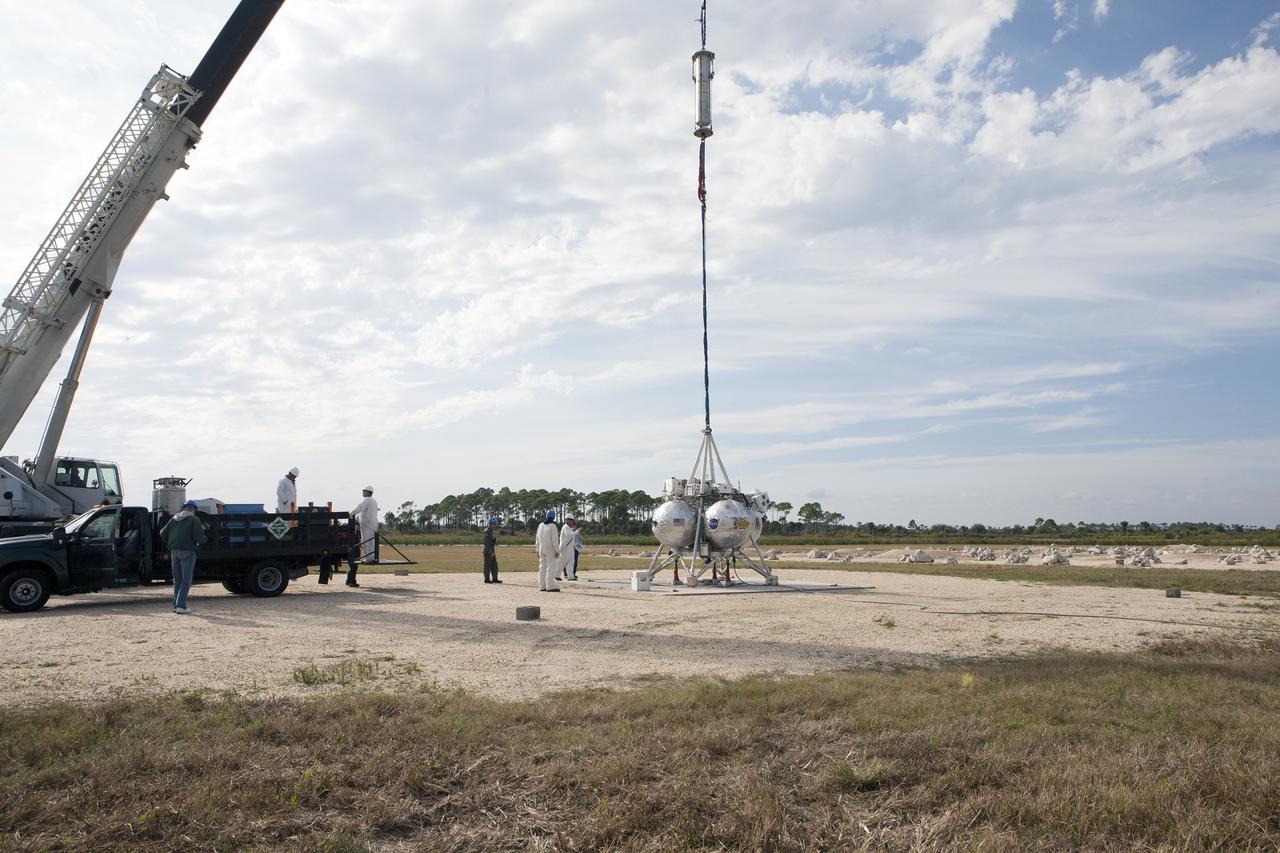 CAPE CANAVERAL, Fla. –NASA's Project Morpheus prototype lander is prepared for lifting by a crane in preparation for a tethered-flight test at the north end of the Shuttle Landing Facility at NASA’s Kennedy Space Center in Florida. For the 40-second test, the lander will be hoisted 20 feet. The spacecraft will ascend an additional five feet and hover for five seconds. Morpheus then will perform a 5.6-foot ascent coupled with a 9.8-foot traverse, and hover for five more seconds before returning to the launch point. A number of changes have been made, primarily focused on autonomous landing and hazard avoidance technology ALHAT and moving the Doppler Lidar to the front of the forward liquid oxygen tank.    The tether test was cut short due to Morpheus exceeding onboard abort rate limits. The vehicle was taken back to the hangar and data from the test is being studied. After review, managers will determine when a new test date will be set. The landing facility provides the lander with the kind of field necessary for realistic testing, complete with rocks, craters and hazards to avoid. Morpheus’ ALHAT payload allows it to navigate to clear landing sites amidst rocks, craters and other hazards during its descent. For more information on Project Morpheus, visit http://morpheuslander.jsc.nasa.gov/. Photo credit: NASA/Kim Shiflett