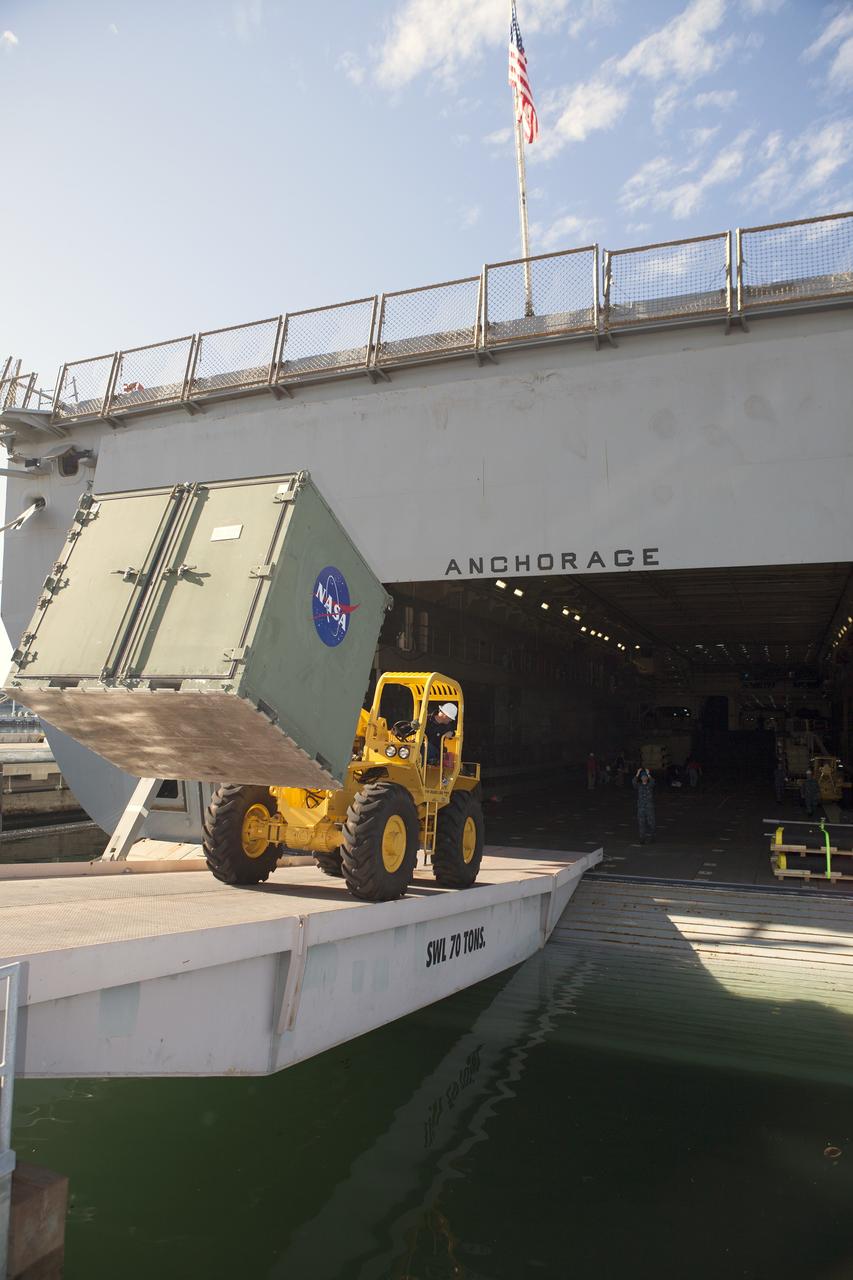 SAN DIEGO, Calif. – A forklift is used to carry ground support equipment into the well deck of the USS Anchorage at Naval Base San Diego in California. The equipment will be used during recovery of the Orion crew module after its first flight test. Before launch of Orion on a Delta IV Heavy rocket from Cape Canaveral Air Force Station in Florida, NASA, Lockheed Martin and U.S. Navy personnel will head out to sea in the USS Anchorage and the USNS Salvor, a salvage ship, and wait for splashdown of the Orion crew module in the Pacific Ocean.    The Ground Systems Development and Operations Program will lead the recovery efforts. Orion is the exploration spacecraft designed to carry astronauts to destinations not yet explored by humans, including an asteroid and Mars. It will have emergency abort capability, sustain the crew during space travel and provide safe re-entry from deep space return velocities. The first unpiloted flight test of Orion is scheduled to launch in December atop a United Launch Alliance Delta IV Heavy rocket and in 2018 on NASA’s Space Launch System rocket. For more information, visit http://www.nasa.gov/orion. Photo credit: NASA/Dimitri Gerondidakis