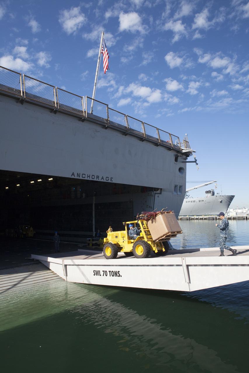 SAN DIEGO, Calif. – A forklift is used to carry ground support equipment into the well deck of the USS Anchorage at Naval Base San Diego in California. The equipment will be used during recovery of the Orion crew module after its first flight test. Before launch of Orion on a Delta IV Heavy rocket from Cape Canaveral Air Force Station in Florida, NASA, Lockheed Martin and U.S. Navy personnel will head out to sea in the USS Anchorage and the USNS Salvor, a salvage ship, and wait for splashdown of the Orion crew module in the Pacific Ocean. The Ground Systems Development and Operations Program will lead the recovery efforts. Orion is the exploration spacecraft designed to carry astronauts to destinations not yet explored by humans, including an asteroid and Mars. It will have emergency abort capability, sustain the crew during space travel and provide safe re-entry from deep space return velocities. The first unpiloted flight test of Orion is scheduled to launch in December atop a United Launch Alliance Delta IV Heavy rocket and in 2018 on NASA’s Space Launch System rocket. For more information, visit http://www.nasa.gov/orion. Photo credit: NASA/Dimitri Gerondidakis