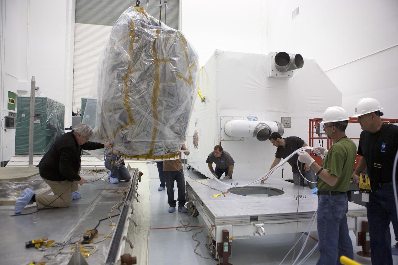 CAPE CANAVERAL, Fla. – NOAA’s Deep Space Climate Observatory spacecraft, or DSCOVR, wrapped in plastic, is transferred from its transportation pallet to a portable work stand at the Astrotech payload processing facility in Titusville, Florida, near Kennedy Space Center. DSCOVR is a partnership between NOAA, NASA and the U.S. Air Force. DSCOVR will maintain the nation's real-time solar wind monitoring capabilities which are critical to the accuracy and lead time of NOAA's space weather alerts and forecasts. Launch is currently scheduled for January 2015 aboard a SpaceX Falcon 9 v 1.1 launch vehicle from Cape Canaveral Air Force Station, Florida. To learn more about DSCOVR, visit http://www.nesdis.noaa.gov/DSCOVR. Photo credit: NASA/Kim Shiflett