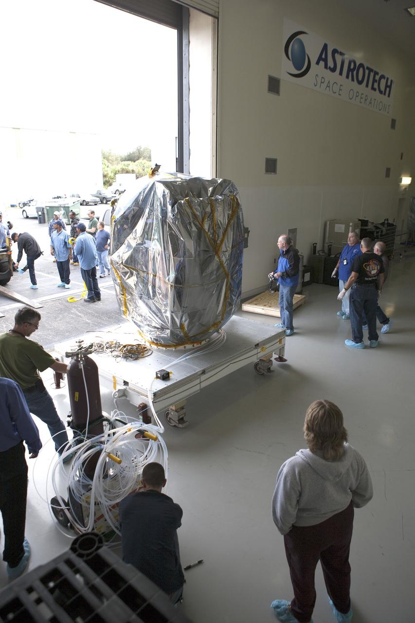CAPE CANAVERAL, Fla. – Workers are on hand to receive NOAA’s Deep Space Climate Observatory spacecraft, or DSCOVR, wrapped in plastic and secured onto a portable work stand, into the high bay of Building 1 at the Astrotech payload processing facility in Titusville, Florida, near Kennedy Space Center.    DSCOVR is a partnership between NOAA, NASA and the U.S. Air Force. DSCOVR will maintain the nation's real-time solar wind monitoring capabilities which are critical to the accuracy and lead time of NOAA's space weather alerts and forecasts. Launch is currently scheduled for January 2015 aboard a SpaceX Falcon 9 v 1.1 launch vehicle from Cape Canaveral Air Force Station, Florida. To learn more about DSCOVR, visit http://www.nesdis.noaa.gov/DSCOVR.  Photo credit: NASA/Kim Shiflett