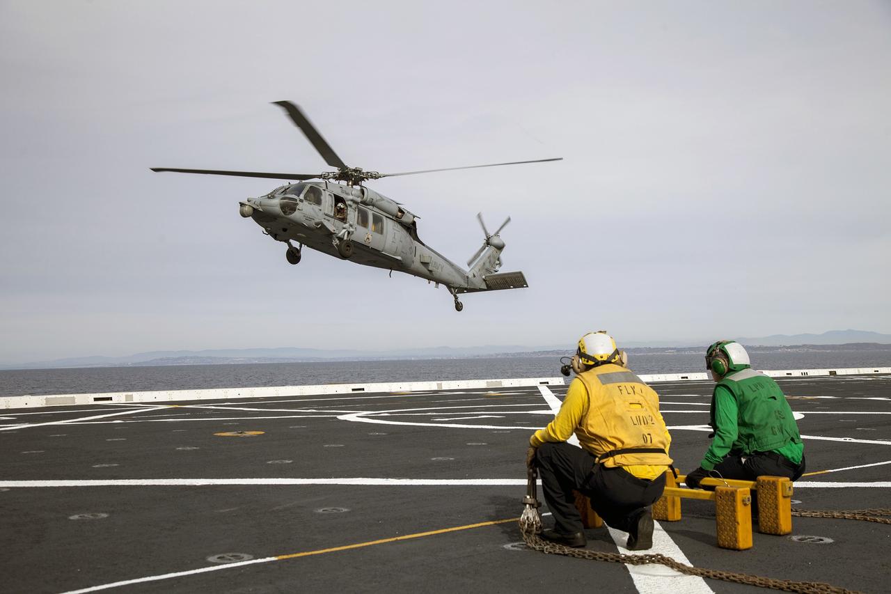 SAN DIEGO, Calif. – An H60-S Seahawk helicopter lands on the deck of the USS Anchorage in the Pacific Ocean off the coast of California. NASA and the U.S. Navy are heading out to sea ahead of Orion's flight test to prepare for recovery of the crew module, forward bay cover and parachutes on its return from space and splashdown in the Pacific Ocean. The Ground Systems Development and Operations Program is leading the recovery efforts.    The first unpiloted flight test of Orion is scheduled to launch this week atop a United Launch Alliance Delta IV Heavy rocket. During its two-orbit, 4.5-hour flight, Orion will venture 3,600 miles in altitude and travel nearly 60,000 miles before returning to Earth for a splashdown in the Pacific Ocean. For more information, visit http://www.nasa.gov/orion. Photo credit: NASA/Cory Huston