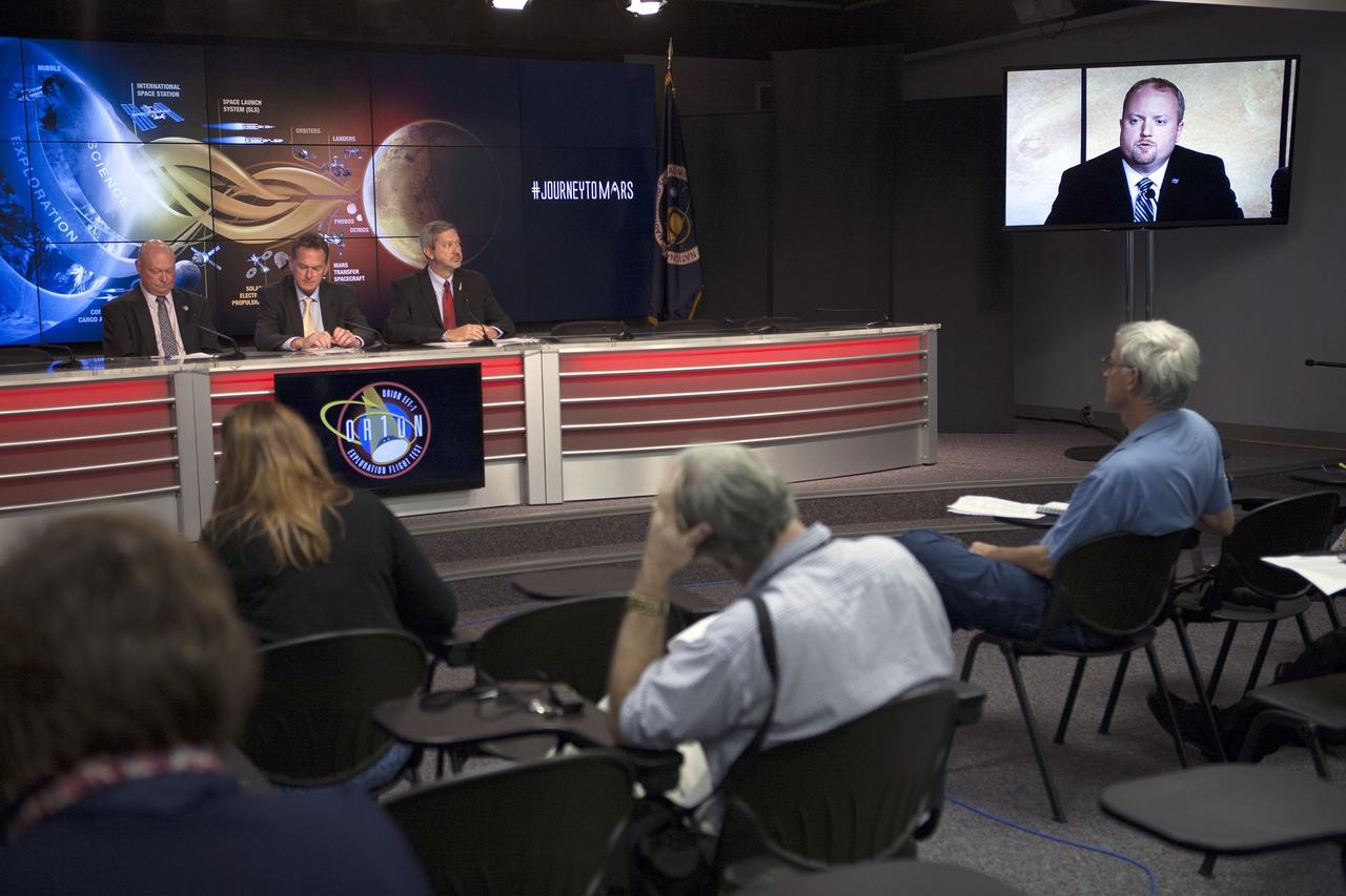 CAPE CANAVERAL, Fla. – At NASA's Kennedy Space Center in Florida, NASA leaders spoke to members of the news media about how the first flight of the new Orion spacecraft is a first step in the agency's plans to send humans to Mars. At Kennedy's News Center auditorium from the left are: Mike Curie of NASA Public Affairs, Mike Bolger, program manager of Ground Systems Development and Operations Program, and Chris Crumbly, manager of Space Launch System Spacecraft/Payload Integration and Evolution. Participating via video from the agency's headquarters in Washington included Jason Crusan, director of Advanced Exploration Systems Division of Human Exploration and Operations Mission Directorate, seen on the monitor on the right.      Orion is the exploration spacecraft designed to carry astronauts to destinations not yet explored by humans, including an asteroid and Mars. It will have emergency abort capability, sustain the crew during space travel and provide safe re-entry from deep space return velocities. The first unpiloted flight test of Orion is scheduled to launch Dec. 4, 2014 atop a United Launch Alliance Delta IV Heavy rocket, and in 2018 on NASA’s Space Launch System rocket. For more information, visit www.nasa.gov/orion Photo credit: NASA/Kim Shiflett
