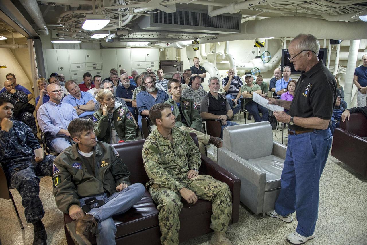 SAN DIEGO, Calif. – NASA, Lockheed Martin and U.S. Navy personnel listen to former space shuttle flight director and mission operations executive Milt Heflin during Orion recovery preparations aboard the USS Anchorage in the Pacific Ocean. Heflin was on prime recovery ships during the splashdowns and post-landing activities of Apollo 8, 10, 16 and 17, each of the three Skylab missions and the Apollo-Soyuz Test Project. NASA and the U.S. Navy are preparing for recovery of the Orion crew module, forward bay cover and parachutes on its return from space and splashdown in the Pacific Ocean. The Ground Systems Development and Operations Program is leading the recovery efforts.    The first unpiloted flight test of Orion is scheduled to launch this week atop a United Launch Alliance Delta IV Heavy rocket. During its two-orbit, 4.5-hour flight, Orion will venture 3,600 miles in altitude and travel nearly 60,000 miles before returning to Earth for a splashdown in the Pacific Ocean. For more information, visit http://www.nasa.gov/orion. Photo credit: NASA/Cory Huston