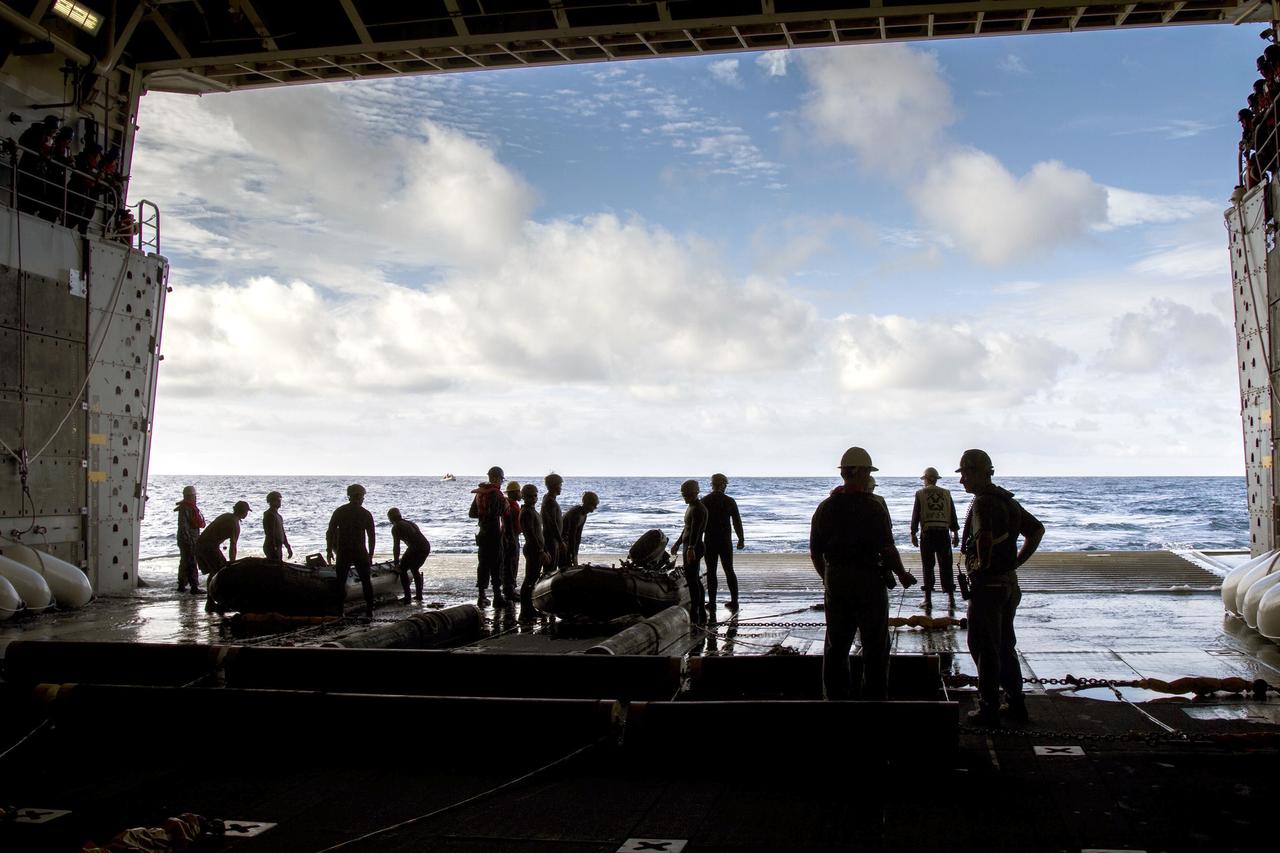SAN DIEGO, Calif. – On the third day of preparations for recovery of Orion after its splashdown in the Pacific Ocean, U.S. Navy Divers prepare to embark from the well deck of the USS Anchorage in two rigid hull Zodiac boats about 600 miles off the coast of Baja, California. NASA, Lockheed Martin and U.S. Navy personnel are preparing for recovery of the crew module, forward bay cover and parachutes on its return from space and splashdown in the Pacific Ocean. The Ground Systems Development and Operations Program is leading the recovery efforts.    The first unpiloted flight test of Orion is scheduled to launch Dec. 4 atop a United Launch Alliance Delta IV Heavy rocket. During its two-orbit, 4.5-hour flight, Orion will venture 3,600 miles in altitude and travel nearly 60,000 miles before returning to Earth for a splashdown in the Pacific Ocean. For more information, visit http://www.nasa.gov/orion. Photo credit: NASA/Cory Huston