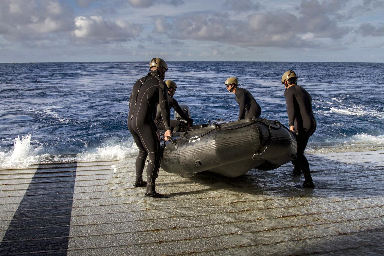 SAN DIEGO, Calif. – On the third day of preparations for recovery of Orion after its splashdown in the Pacific Ocean, U.S. Navy Divers prepare to embark from the well deck of the USS Anchorage in a rigid hull Zodiac boat about 600 miles off the coast of Baja, California. NASA, Lockheed Martin and U.S. Navy personnel are preparing for recovery of the crew module, forward bay cover and parachutes on its return from space and splashdown in the Pacific Ocean. The Ground Systems Development and Operations Program is leading the recovery efforts. The first unpiloted flight test of Orion is scheduled to launch Dec. 4 atop a United Launch Alliance Delta IV Heavy rocket. During its two-orbit, 4.5-hour flight, Orion will venture 3,600 miles in altitude and travel nearly 60,000 miles before returning to Earth for a splashdown in the Pacific Ocean. For more information, visit http://www.nasa.gov/orion. Photo credit: NASA/Cory Huston