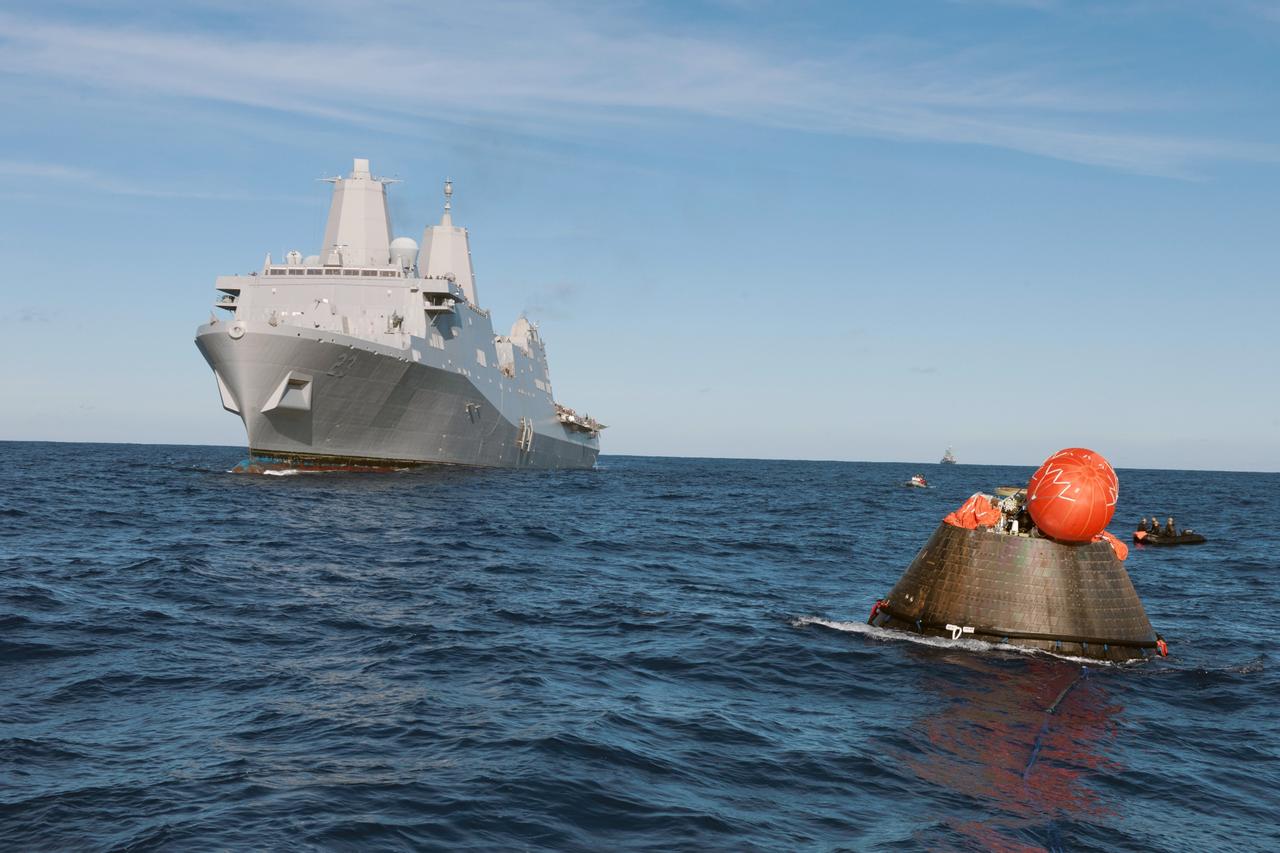 SAN DIEGO, Calif. -- NASA's Orion spacecraft floats in the Pacific Ocean after splashdown from its first flight test in Earth orbit. The USS Anchorage is nearby. NASA, the U.S. Navy and Lockheed Martin are coordinating efforts to recover Orion and secure the spacecraft in the well deck of the USS Anchorage. Orion completed a two-orbit, four-and-a-half hour mission, to test systems critical to crew safety, including the launch abort system, the heat shield and the parachute system. The Ground Systems Development and Operations Program is leading the recovery efforts. For more information, visit www.nasa.gov/orion Photo credit: NASA/Tony Gray