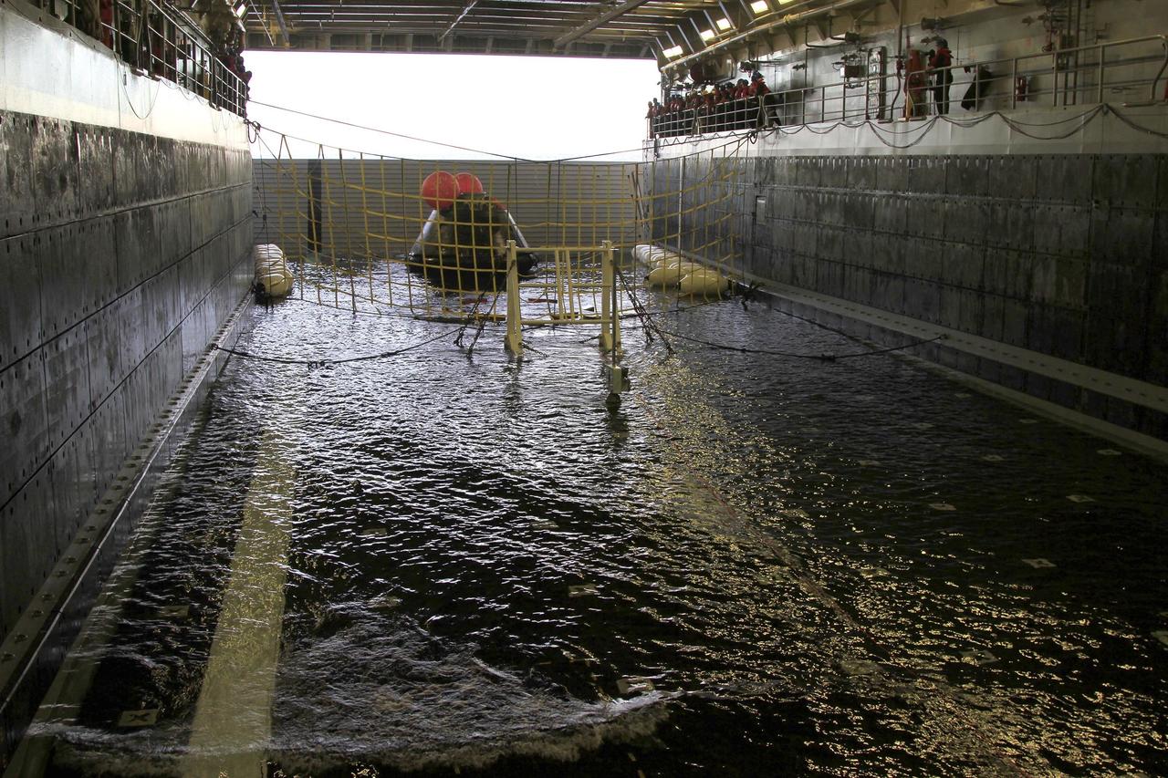 SAN DIEGO, Calif. -- After splashdown, NASA's Orion spacecraft has been recovered and is positioned on rubber "speed bumps" inside the flooded well deck of the USS Anchorage in the Pacific Ocean about 600 miles off the coast of San Diego, California. After lifting off at 7:05 a.m. EST atop a Delta IV Heavy rocket from Space Launch Complex 37 at Cape Canaveral Air Force Station in Florida, Orion completed a two-orbit, four-and-a-half hour mission to test systems critical to crew safety, including the launch abort system, the heat shield and the parachute system. NASA, the U.S. Navy and Lockheed Martin coordinated efforts to recover Orion after splashdown. The Ground Systems Development and Operations Program is leading the recovery efforts. For more information, visit www.nasa.gov/orion Photo credit: NASA/Cory Huston