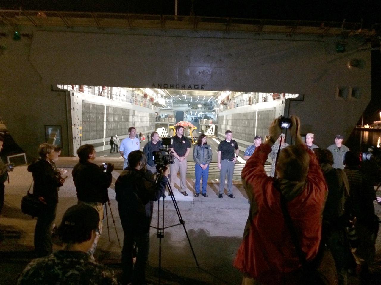 SAN DIEGO, Calif. -- At Naval Base San Diego in California, members of the news media view NASA's Orion spacecraft in the well deck of the USS Anchorage before it is offloaded and prepared for return to Kennedy Space Center in Florida. Speaking to the media are NASA and U.S. Navy officials. After lifting off at 7:05 a.m. EST on Dec. 5 atop a Delta IV Heavy rocket from Space Launch Complex 37 at Cape Canaveral Air Force Station in Florida, Orion completed a two-orbit, four-and-a-half hour mission to test systems critical to crew safety, including the launch abort system, the heat shield and the parachute system. NASA, the U.S. Navy and Lockheed Martin coordinated efforts to recover Orion after splashdown in the Pacific Ocean. The GSDO Program led the recovery efforts. For more information, visit www.nasa.gov/orion Photo credit: NASA/Amber Philman