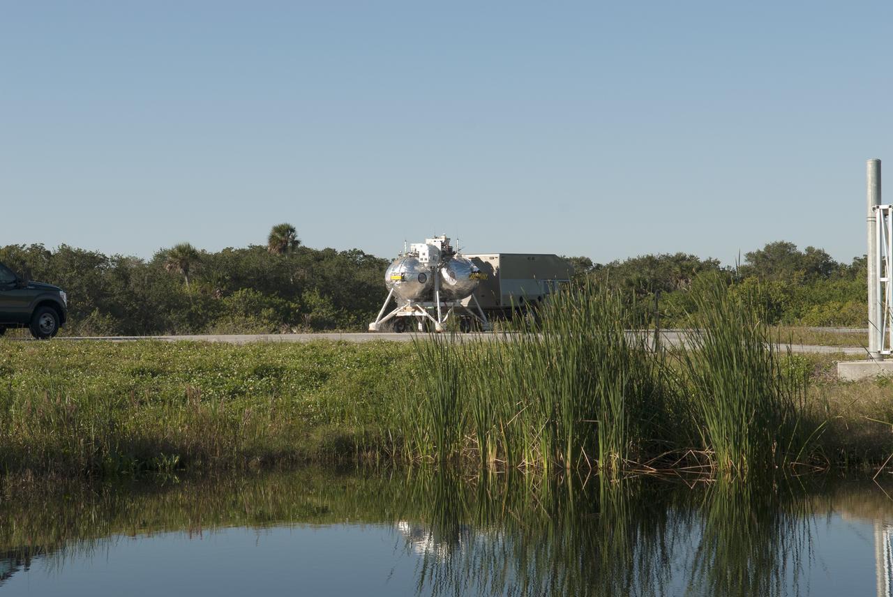 CAPE CANAVERAL, Fla. – NASA's Project Morpheus prototype lander is being transported to the north end of the Shuttle Landing Facility for free flight test number 15 at NASA’s Kennedy Space Center in Florida. The lander will take off from the ground over a flame trench and use its autonomous landing and hazard avoidance technology, or ALHAT sensors, to survey the hazard field to determine safe landing sites. Project Morpheus tests NASA’s ALHAT and an engine that runs on liquid oxygen and methane, which are green propellants. These new capabilities could be used in future efforts to deliver cargo to planetary surfaces. Project Morpheus is being managed under the Advanced Exploration Systems, or AES, Division in NASA’s Human Exploration and Operations Mission Directorate. For more information on Project Morpheus, visit http://morpheuslander.jsc.nasa.gov/.  Photo credit: NASA/Jim Grossmann