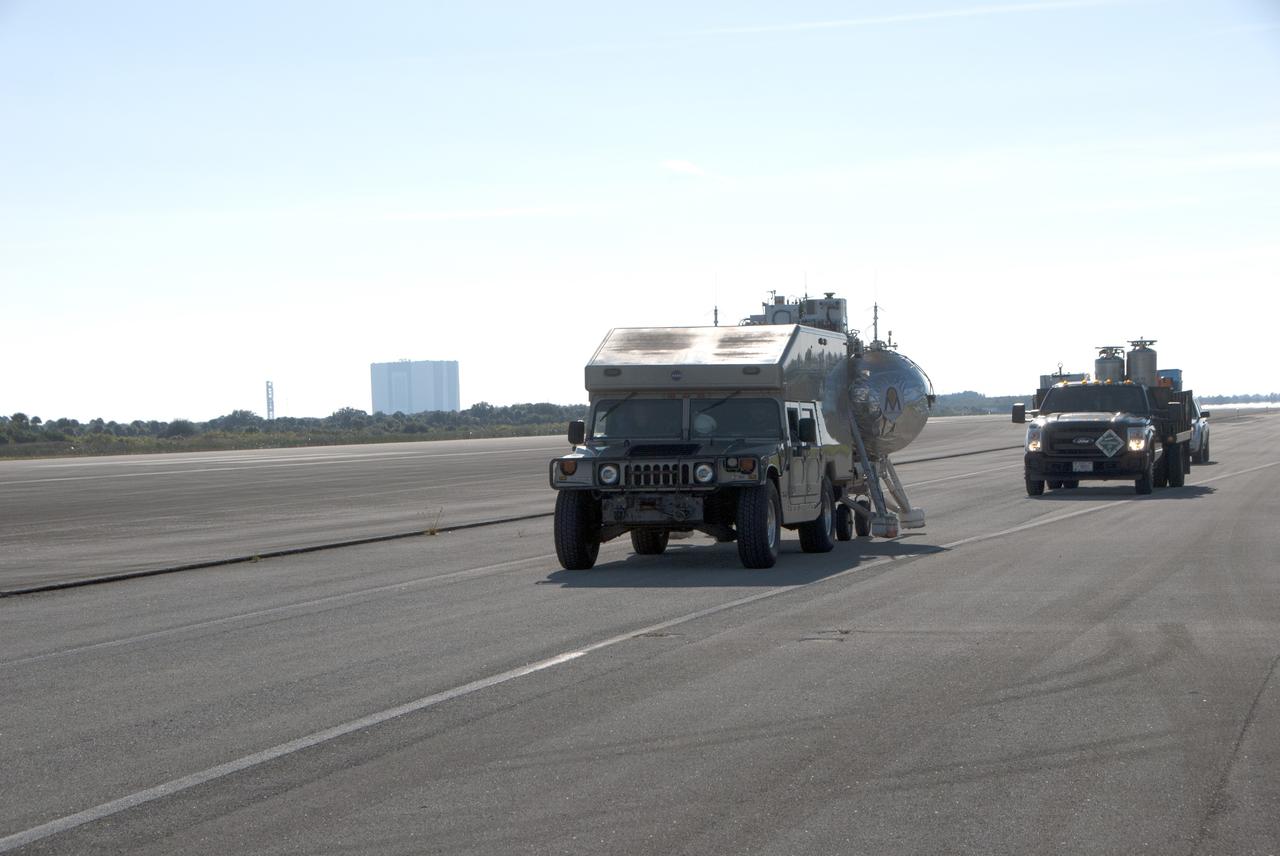 CAPE CANAVERAL, Fla. – NASA Project Morpheus prototype lander and support equipment are being transported to the north end of the Shuttle Landing Facility for free flight test number 15 at NASA’s Kennedy Space Center in Florida. The lander will take off from the ground over a flame trench and use its autonomous landing and hazard avoidance technology, or ALHAT sensors, to survey the hazard field to determine safe landing sites. Project Morpheus tests NASA’s ALHAT and an engine that runs on liquid oxygen and methane, which are green propellants. These new capabilities could be used in future efforts to deliver cargo to planetary surfaces. Project Morpheus is being managed under the Advanced Exploration Systems, or AES, Division in NASA’s Human Exploration and Operations Mission Directorate. For more information on Project Morpheus, visit http://morpheuslander.jsc.nasa.gov/.  Photo credit: NASA/Jim Grossmann
