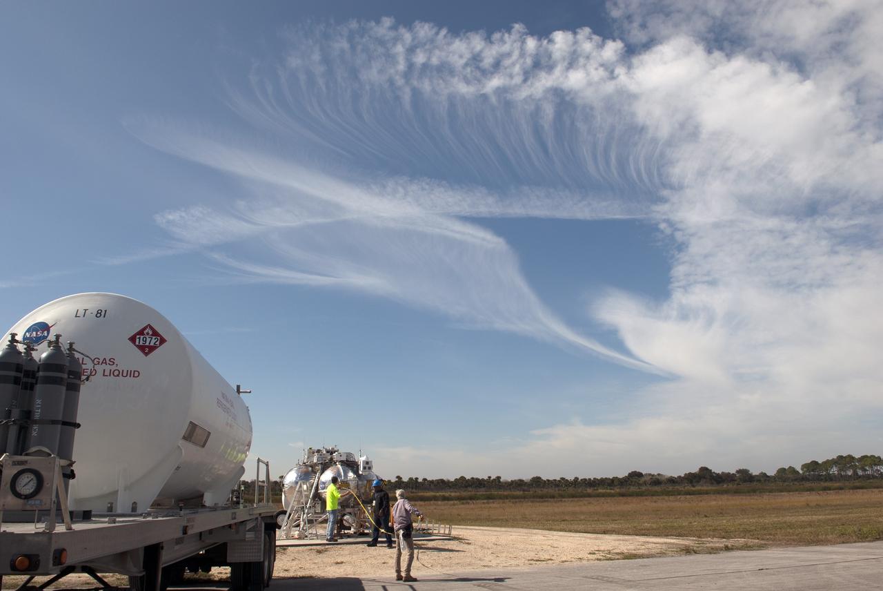 CAPE CANAVERAL, Fla. – Engineers and technicians prepare NASA's Project Morpheus prototype lander for free flight test number 15 at the north end of the Shuttle Landing Facility at NASA's Kennedy Space Center in Florida. The lander will take off from the ground over a flame trench and use its autonomous landing and hazard avoidance technology, or ALHAT sensors, to survey the hazard field to determine safe landing sites. Project Morpheus tests NASA’s ALHAT and an engine that runs on liquid oxygen and methane, which are green propellants. These new capabilities could be used in future efforts to deliver cargo to planetary surfaces. Project Morpheus is being managed under the Advanced Exploration Systems, or AES, Division in NASA’s Human Exploration and Operations Mission Directorate. For more information on Project Morpheus, visit http://morpheuslander.jsc.nasa.gov/.  Photo credit: NASA/Jim Grossmann