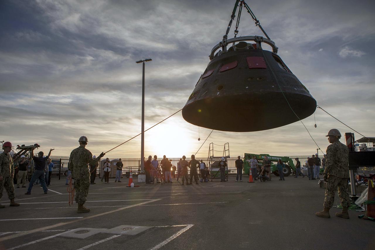 SAN DIEGO, Calif. -- The Orion crew module is being moved by crane from its crew module recovery cradle and will be placed in the crew module transportation fixture at the Mole Pier at Naval Base San Diego in California. The fixture has been secured on the back of a flatbed truck. Orion is being prepared for the overland trip back to NASA's Kennedy Space Center in Florida. Orion was recovered from the Pacific Ocean after completing a two-orbit, four-and-a-half hour mission Dec. 5 to test systems critical to crew safety, including the launch abort system, the heat shield and the parachute system. NASA, the U.S. Navy and Lockheed Martin coordinated efforts to recover Orion. The Ground Systems Development and Operations Program led the recovery, offload and pre-transportation efforts. For more information, visit www.nasa.gov/orion Photo credit: NASA/Cory Huston