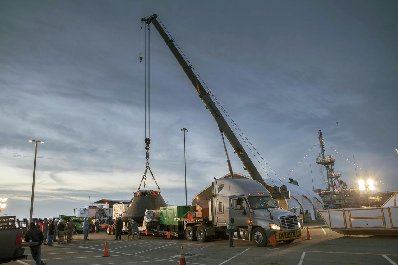SAN DIEGO, Calif. -- The Orion crew module is being lowered onto the crew module transportation fixture at the Mole Pier at Naval Base San Diego in California. The fixture has been secured on the back of a flatbed truck. Orion is being prepared for the overland trip back to NASA's Kennedy Space Center in Florida. Orion was recovered from the Pacific Ocean after completing a two-orbit, four-and-a-half hour mission Dec. 5 to test systems critical to crew safety, including the launch abort system, the heat shield and the parachute system. NASA, the U.S. Navy and Lockheed Martin coordinated efforts to recover Orion. The Ground Systems Development and Operations Program led the recovery, offload and pre-transportation efforts. For more information, visit www.nasa.gov/orion Photo credit: NASA/Cory Huston