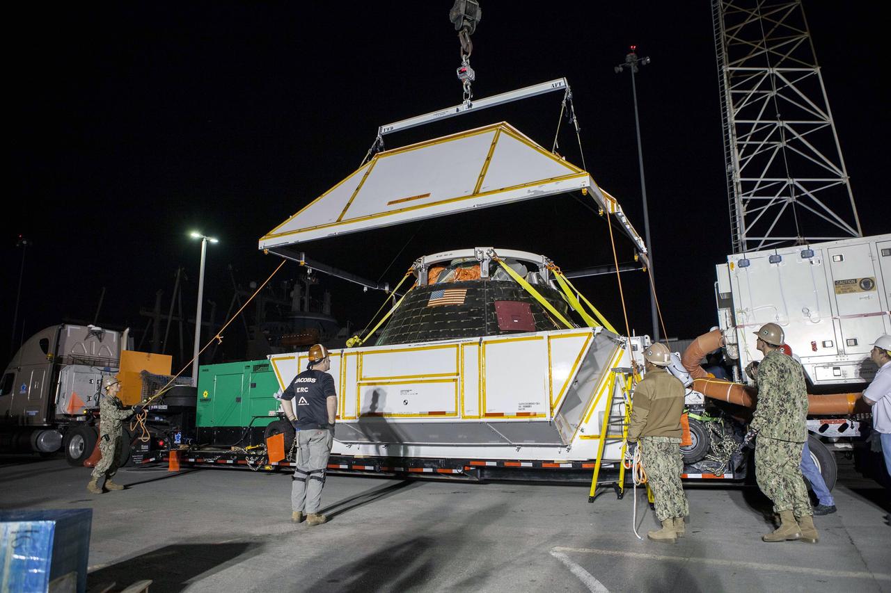 SAN DIEGO, Calif. -- The Orion crew module has been lowered and secured in the crew module transportation fixture at the Mole Pier at Naval Base San Diego in California. The fixture has been secured on the back of a flatbed truck and the cover is being lowered over the spacecraft. Orion is being prepared for the overland trip back to NASA's Kennedy Space Center in Florida. Orion was recovered from the Pacific Ocean after completing a two-orbit, four-and-a-half hour mission Dec. 5 to test systems critical to crew safety, including the launch abort system, the heat shield and the parachute system. NASA, the U.S. Navy and Lockheed Martin coordinated efforts to recover Orion. The Ground Systems Development and Operations Program led the recovery, offload and pre-transportation efforts. For more information, visit www.nasa.gov/orion Photo credit: NASA/Cory Huston