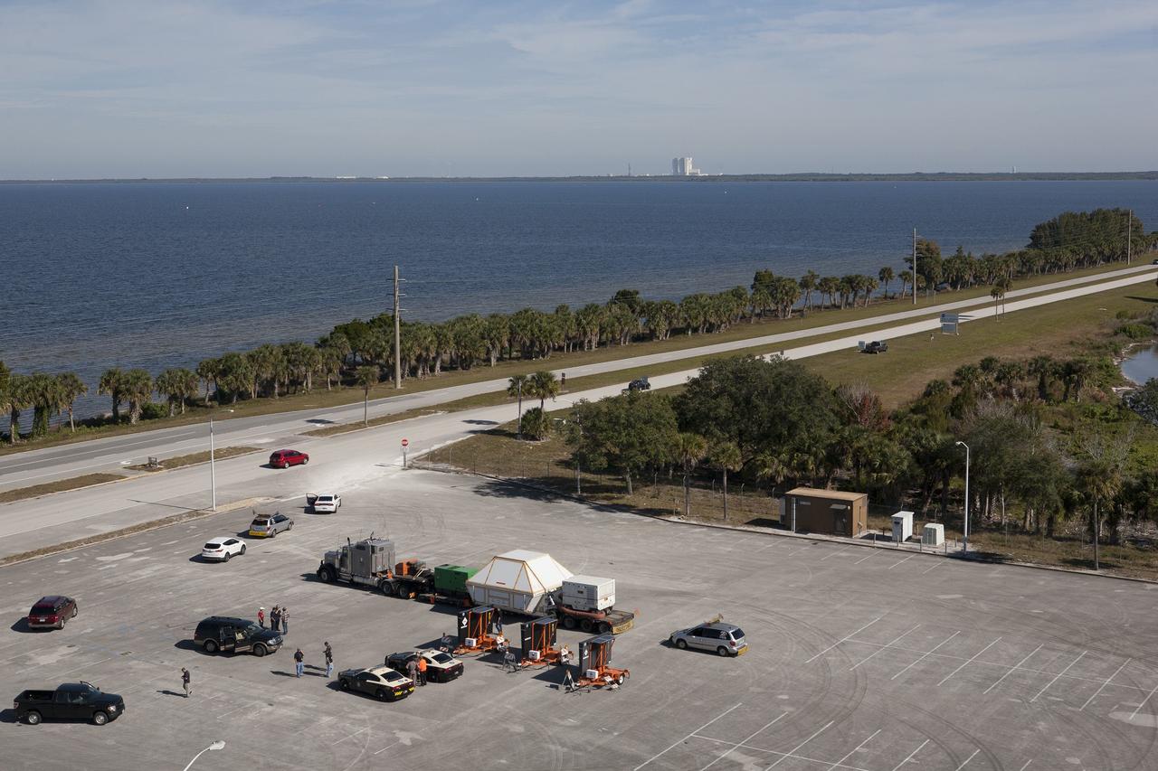CAPE CANAVERAL, Fla. -- An aerial view near NASA's Kennedy Space Center Visitor Complex reveals the Orion crew module, enclosed in its crew module transportation fixture and secured on a flatbed truck that is preparing to pull onto the NASA Causeway that leads to the entrance gate to Kennedy Space Center in Florida. Orion made the 2,700 mile overland trip from Naval Base San Diego in California. The spacecraft was recovered from the Pacific Ocean after completing a two-orbit, four-and-a-half hour mission Dec. 5 to test systems critical to crew safety, including the launch abort system, the heat shield and the parachute system. The Ground Systems Development and Operations Program led the recovery, offload and transportation efforts. For more information, visit www.nasa.gov/orion. Photo credit: NASA/Kim Shiflett