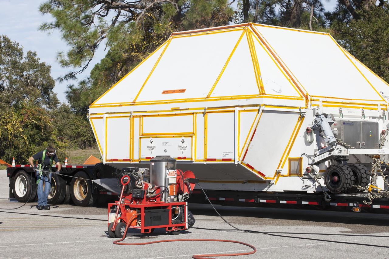 CAPE CANAVERAL, Fla. -- A technician washes down the crew module transportation fixture containing the Orion crew module on the back of a flatbed truck at the Multi-Operation Support Building at NASA's Kennedy Space Center in Florida. Orion was transported 2,700 miles overland from Naval Base San Diego in California. Orion was recovered from the Pacific Ocean after completing a two-orbit, four-and-a-half hour mission Dec. 5 to test systems critical to crew safety, including the launch abort system, the heat shield and the parachute system. The Ground Systems Development and Operations Program led the recovery, offload and transportation efforts. For more information, visit www.nasa.gov/orion. Photo credit: NASA/Kim Shiflett
