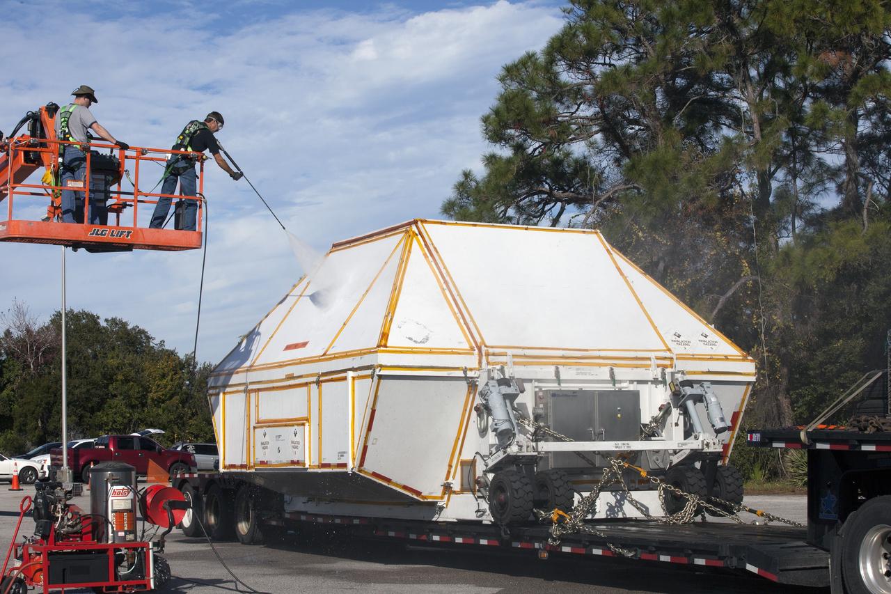 CAPE CANAVERAL, Fla. -- Technicians wash down the crew module transportation fixture containing the Orion crew module on the back of a flatbed truck at the Multi-Operation Support Building at NASA's Kennedy Space Center in Florida. Orion was transported 2,700 miles overland from Naval Base San Diego in California. Orion was recovered from the Pacific Ocean after completing a two-orbit, four-and-a-half hour mission Dec. 5 to test systems critical to crew safety, including the launch abort system, the heat shield and the parachute system. The Ground Systems Development and Operations Program led the recovery, offload and transportation efforts. For more information, visit www.nasa.gov/orion. Photo credit: NASA/Kim Shiflett