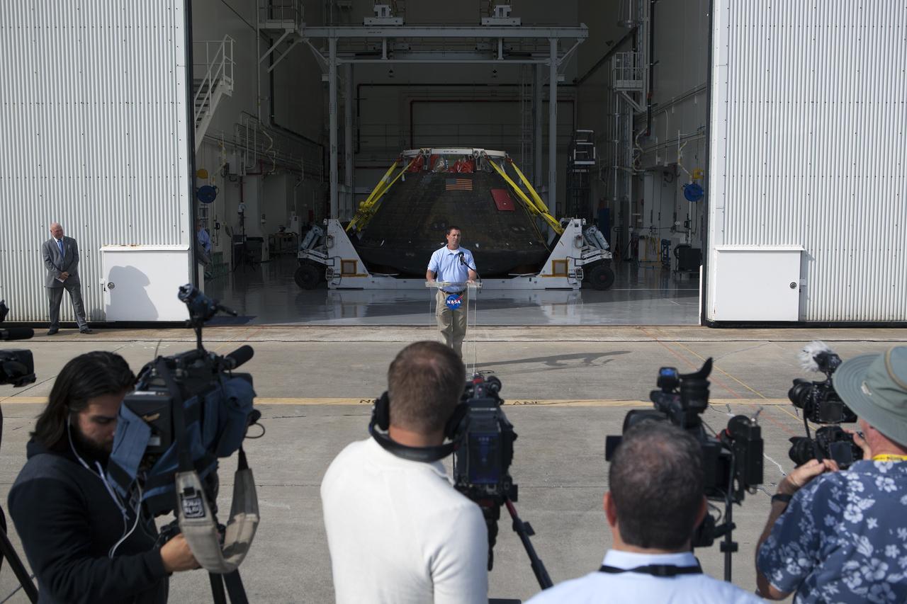 CAPE CANAVERAL, Fla. -- NASA's Orion spacecraft is viewed by members of the media at the Launch Abort System Facility at NASA's Kennedy Space Center in Florida. Lou Garcia, with the Ground Systems Development and Operations Program, or GSDO, speaks to the media during the viewing opportunity. The spacecraft's cross-country return, a 2,700 mile road trip from Naval Base San Diego to Kennedy, sets the stage for in-depth analysis of data obtained during Orion's trip to space. It will provide engineers with detailed information on how the spacecraft fared during its two-orbit, 4.5-hour flight test, completed on Dec. 5. GSDO led the recovery, offload and transportation efforts. For more information, visit www.nasa.gov/orion. Photo credit: NASA/Dimitri Gerondidakis