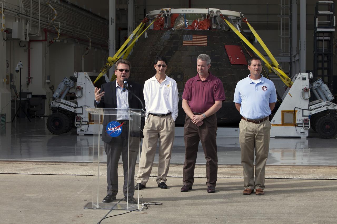 CAPE CANAVERAL, Fla. -- NASA's Orion spacecraft is viewed by members of the media at the Launch Abort System Facility at NASA's Kennedy Space Center in Florida. Speaking to the media during the viewing opportunity is Jules Schneider, Lockheed Martin Manager. Behind him, from left, are Glenn Chin, Orion Production Operations manager and Phil Weber and Lou Garcia, with the Ground Systems Development and Operations Program, or GSDO. Orion made the 8-day, 2,700 mile overland trip back to Kennedy from Naval Base San Diego in California.  Analysis of date obtained during its two-orbit, four-and-a-half hour mission Dec. 5 will provide engineers with detailed information on how the spacecraft fared. GSDO led the recovery, offload and transportation efforts. For more information, visit www.nasa.gov/orion. Photo credit: NASA/Dimitri Gerondidakis