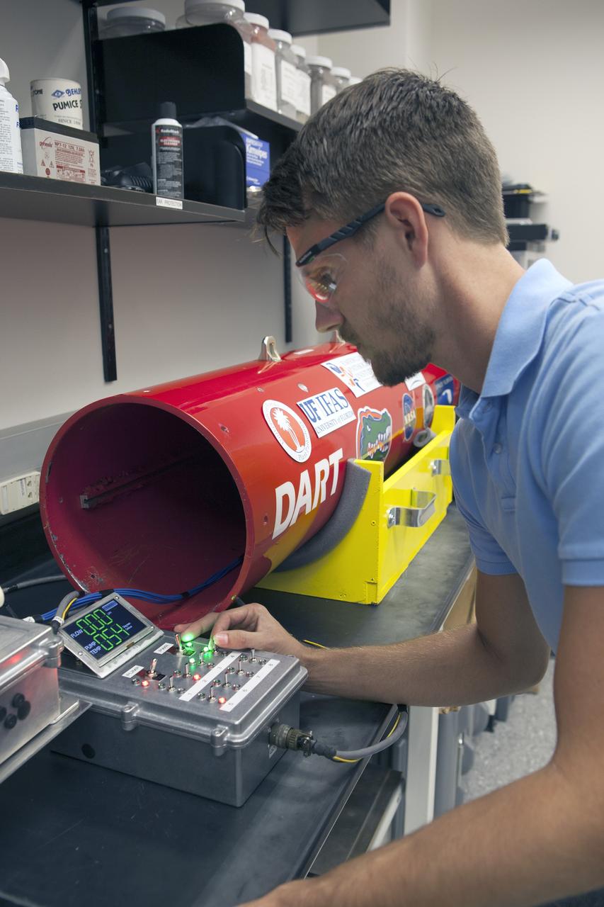 CAPE CANAVERAL, Fla. – A researcher at NASA’s Kennedy Space Center in Florida checks a reading on the Dust Atmospheric Recovery Technology, or DART, spacecraft inside a laboratory at the Space Life Sciences Lab. DART will characterize the dust loading and microbial diversity in the atmosphere over Florida during summer months with a special emphasis on their interactions during an African dust storm. DART will be used to collect atmospheric aerosols and suspended microbial cells over Florida and Kennedy. Results will help predict the risks of excessive microbial contamination adhering to spacecraft surfaces. Photo credit: NASA/Dimitri Gerondidakis