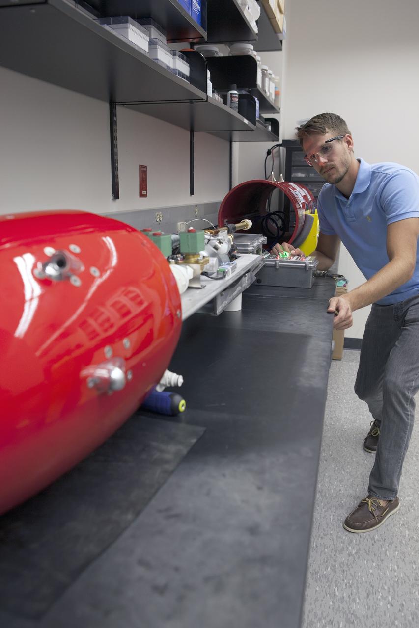 CAPE CANAVERAL, Fla. – A researcher at NASA’s Kennedy Space Center in Florida checks a reading on the Dust Atmospheric Recovery Technology, or DART, spacecraft inside a laboratory at the Space Life Sciences Lab. DART will characterize the dust loading and microbial diversity in the atmosphere over Florida during summer months with a special emphasis on their interactions during an African dust storm. DART will be used to collect atmospheric aerosols and suspended microbial cells over Florida and Kennedy. Results will help predict the risks of excessive microbial contamination adhering to spacecraft surfaces. Photo credit: NASA/Dimitri Gerondidakis
