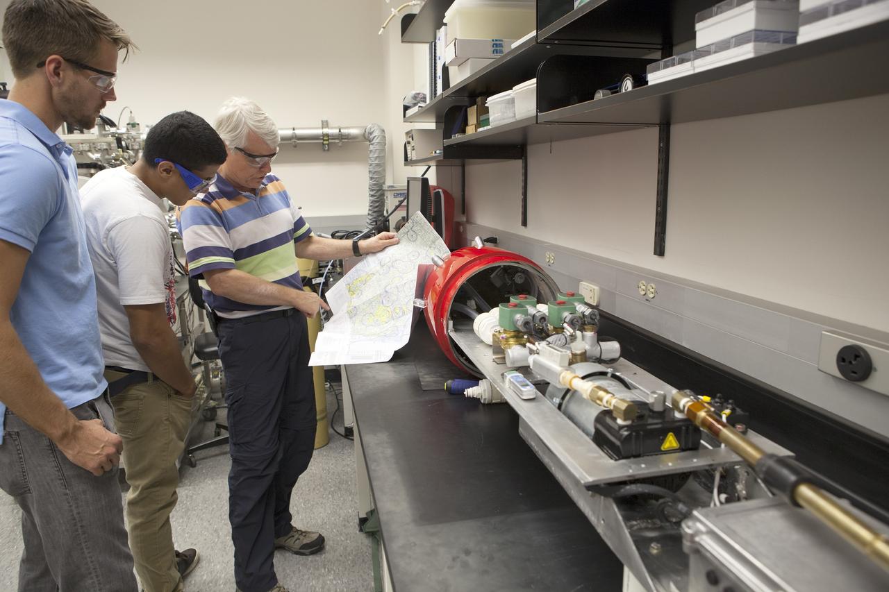 CAPE CANAVERAL, Fla. – Researchers at NASA’s Kennedy Space Center in Florida check readings on the Dust Atmospheric Recovery Technology, or DART, spacecraft inside a laboratory at the Space Life Sciences Lab. DART will characterize the dust loading and microbial diversity in the atmosphere over Florida during summer months with a special emphasis on their interactions during an African dust storm. DART will be used to collect atmospheric aerosols and suspended microbial cells over Florida and Kennedy. Results will help predict the risks of excessive microbial contamination adhering to spacecraft surfaces. Photo credit: NASA/Dimitri Gerondidakis