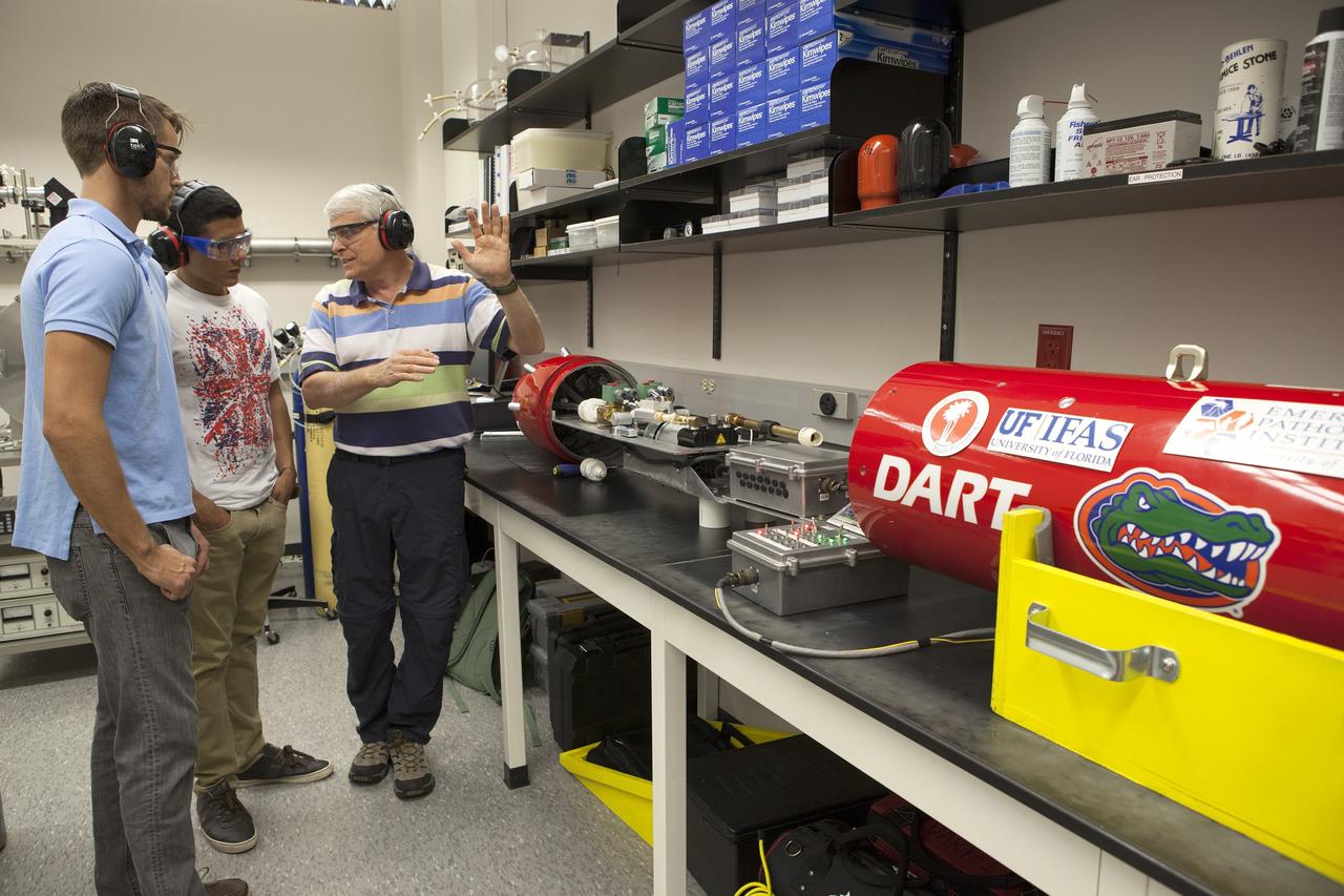 CAPE CANAVERAL, Fla. – Researchers at NASA’s Kennedy Space Center in Florida check readings on the Dust Atmospheric Recovery Technology, or DART, spacecraft inside a laboratory at the Space Life Sciences Lab. DART will characterize the dust loading and microbial diversity in the atmosphere over Florida during summer months with a special emphasis on their interactions during an African dust storm. DART will be used to collect atmospheric aerosols and suspended microbial cells over Florida and Kennedy. Results will help predict the risks of excessive microbial contamination adhering to spacecraft surfaces. Photo credit: NASA/Dimitri Gerondidakis