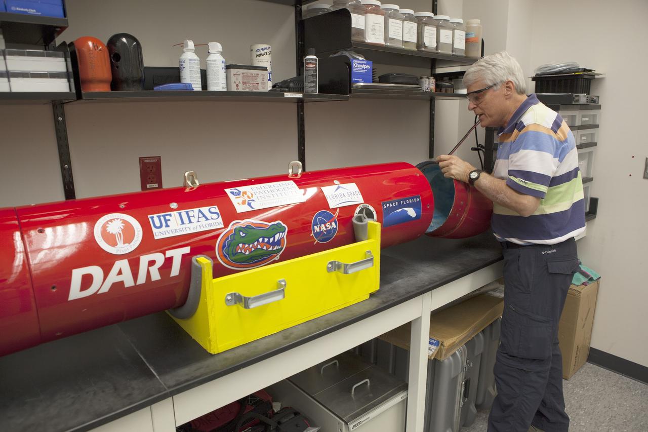 CAPE CANAVERAL, Fla. – A researcher from the University of Florida in Gainesville, checks the Dust Atmospheric Recovery Technology, or DART, spacecraft in a laboratory inside the Space Life Sciences Lab at NASA’s Kennedy Space Center in Florida. DART will characterize the dust loading and microbial diversity in the atmosphere over Florida during summer months with a special emphasis on their interactions during an African dust storm. DART will be used to collect atmospheric aerosols and suspended microbial cells over Florida and Kennedy. Results will help predict the risks of excessive microbial contamination adhering to spacecraft surfaces. Photo credit: NASA/Dimitri Gerondidakis