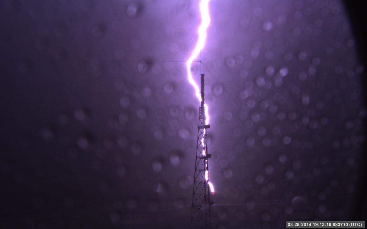 A lightning strike is recorded at Launch Complex 39B at NASA’s Kennedy Space Center in Florida in March 2014. The event was captured by high-speed cameras stationed at the pad and mobile launcher. At pad 39B, there are three, 600-foot-tall masts with overhead wires used to transmit electrical energy around the perimeter of the pad to provide lightning protection for launch vehicles as they are processed and launched from the pad.