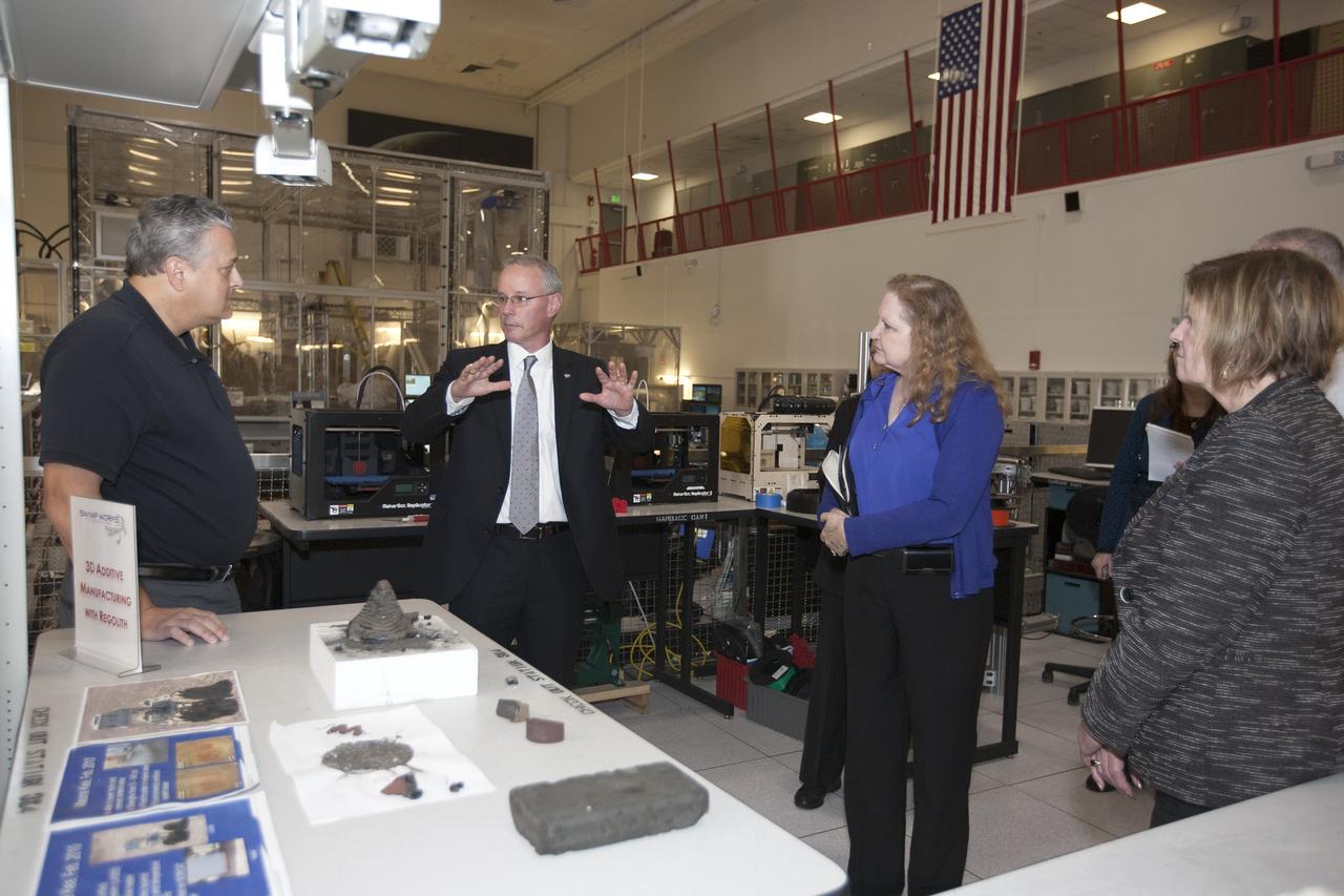 CAPE CANAVERAL, Fla. -- During a visit to NASA's Kennedy Space Center in Florida, NASA Chief Technologist David Miller, second from left, tours laboratories inside the Swamp Works facility. Miller is briefed on technology developments in the lab by Jack Fox, chief of the Surface Systems Office in the Engineering and Technology Directorate. At right is Karen Thompson, Kennedy's chief technologist. Photo credit: NASA/Kim Shiflett